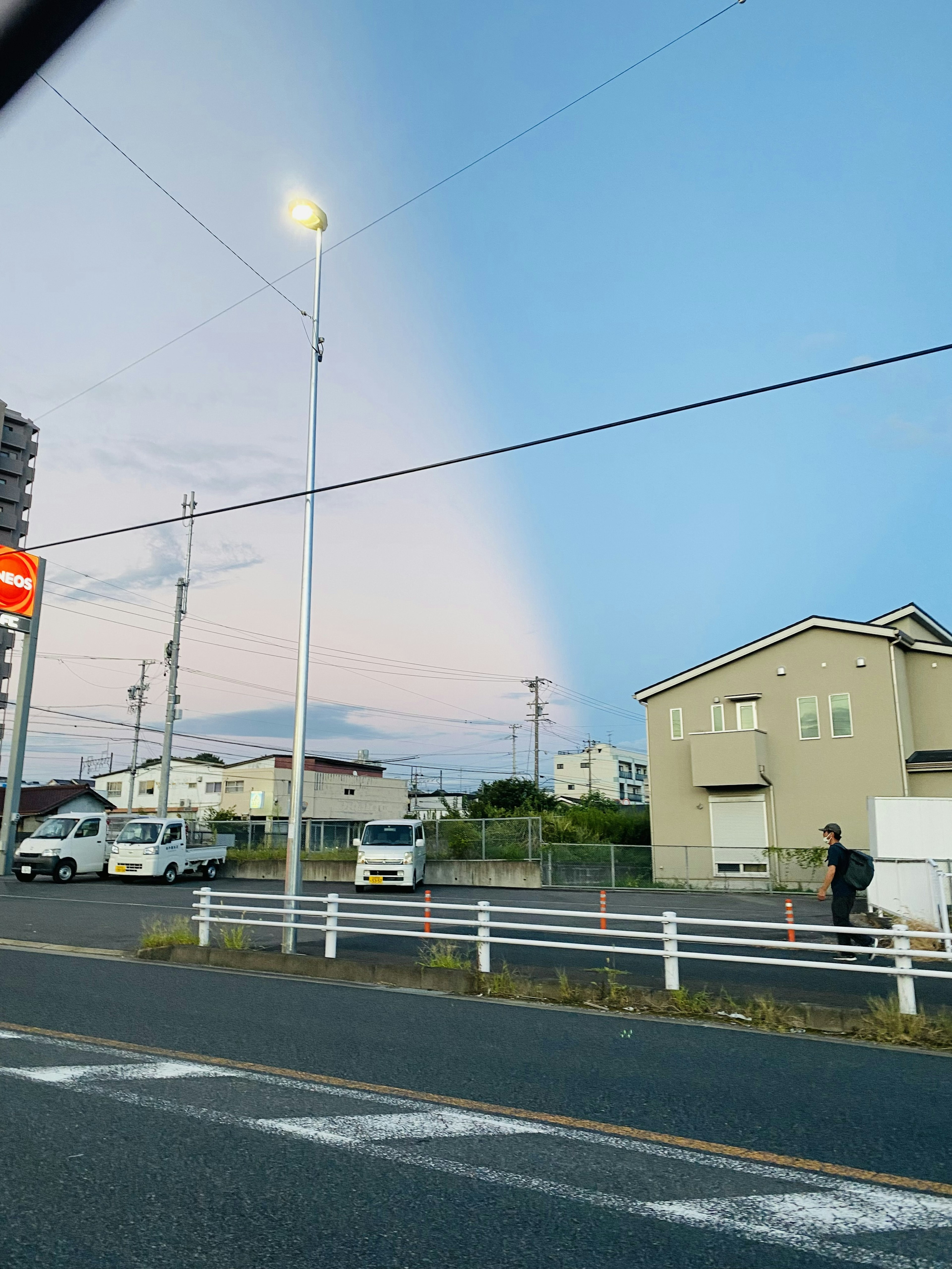 藍天與柔和雲彩的場景以及道路旁的路燈