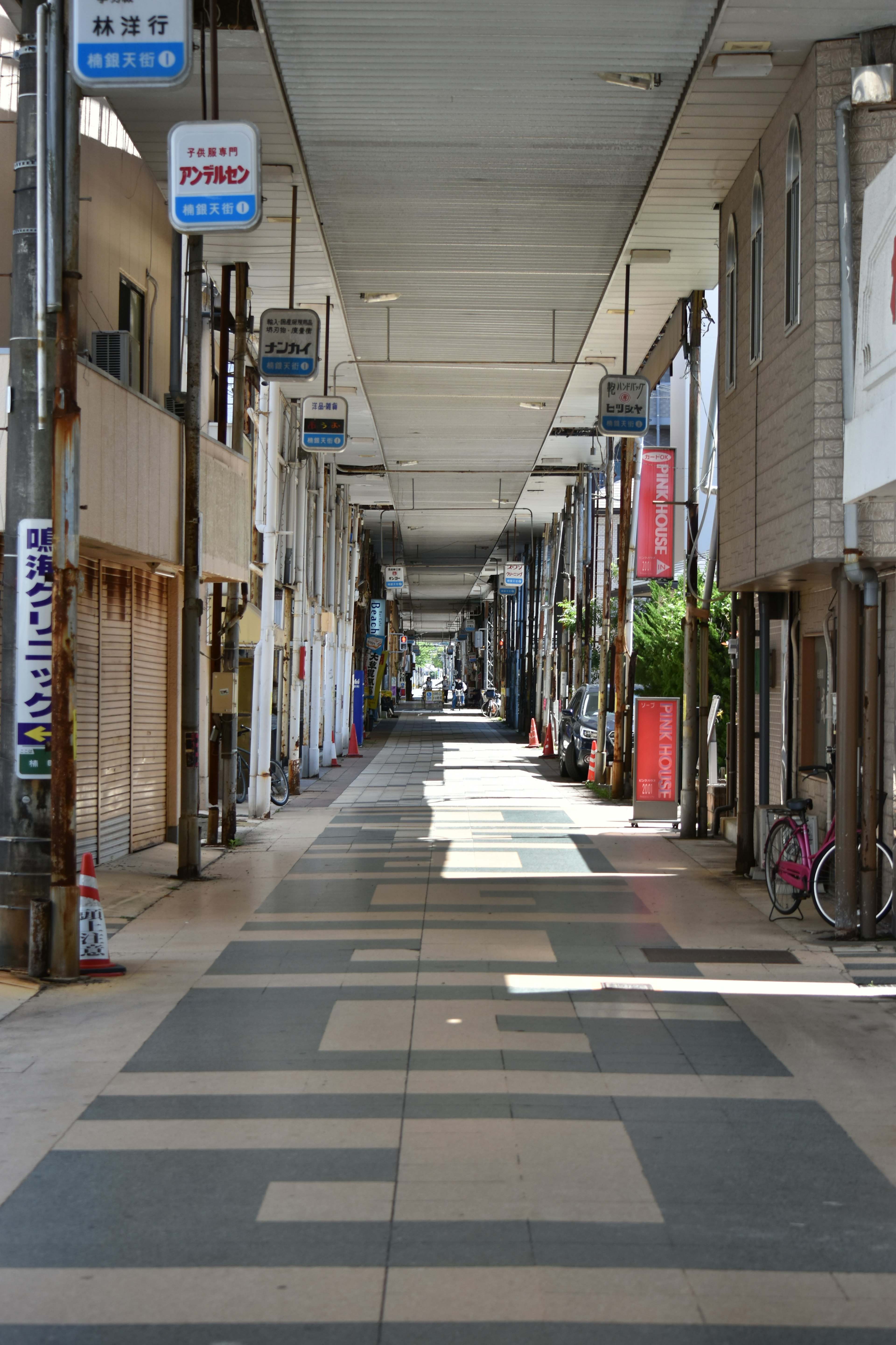 Ruhige Einkaufsstraße mit breitem Gehweg und Schildern