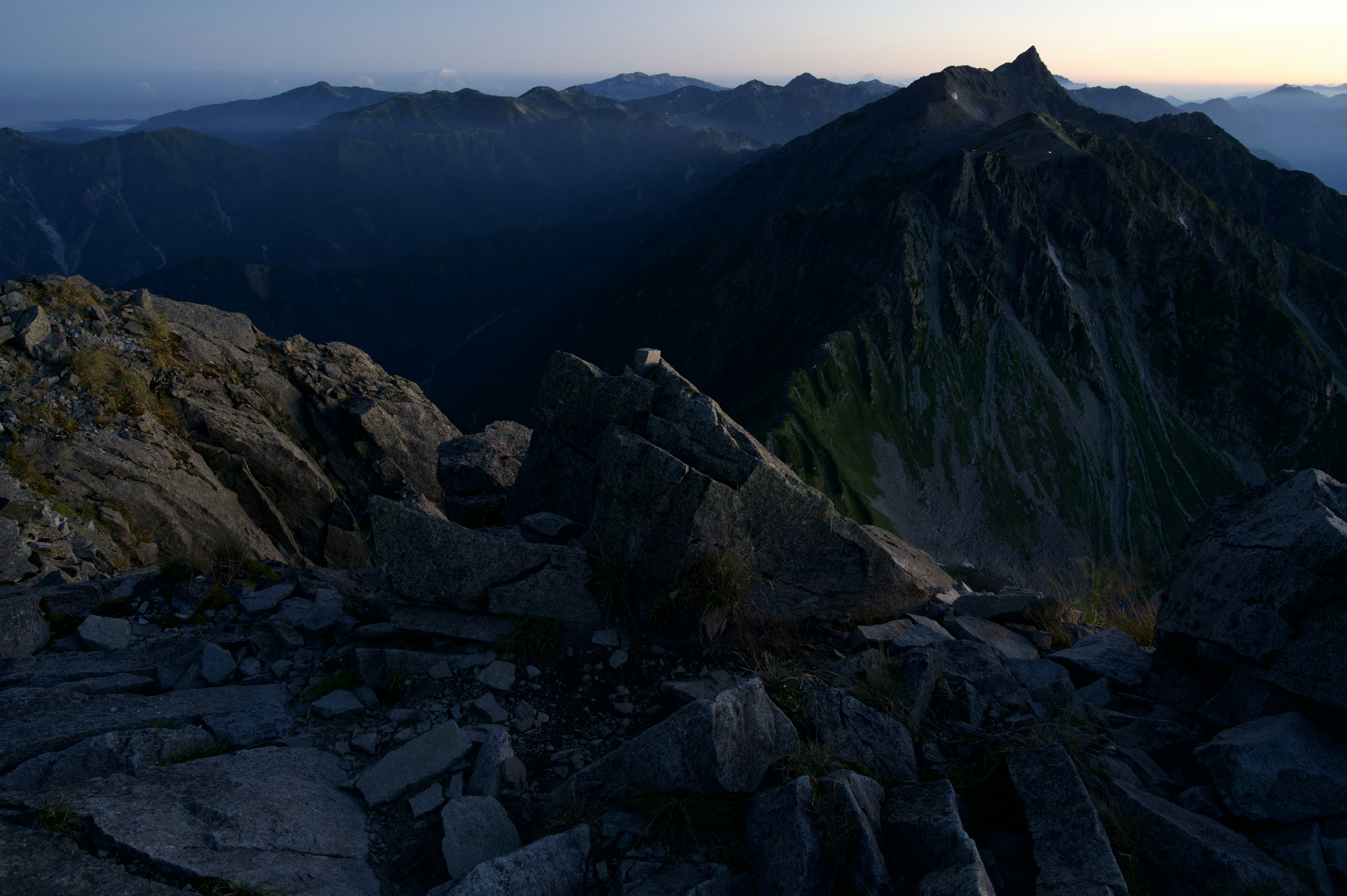 Vue du sommet de la montagne au crépuscule avec des rochers et des montagnes au loin