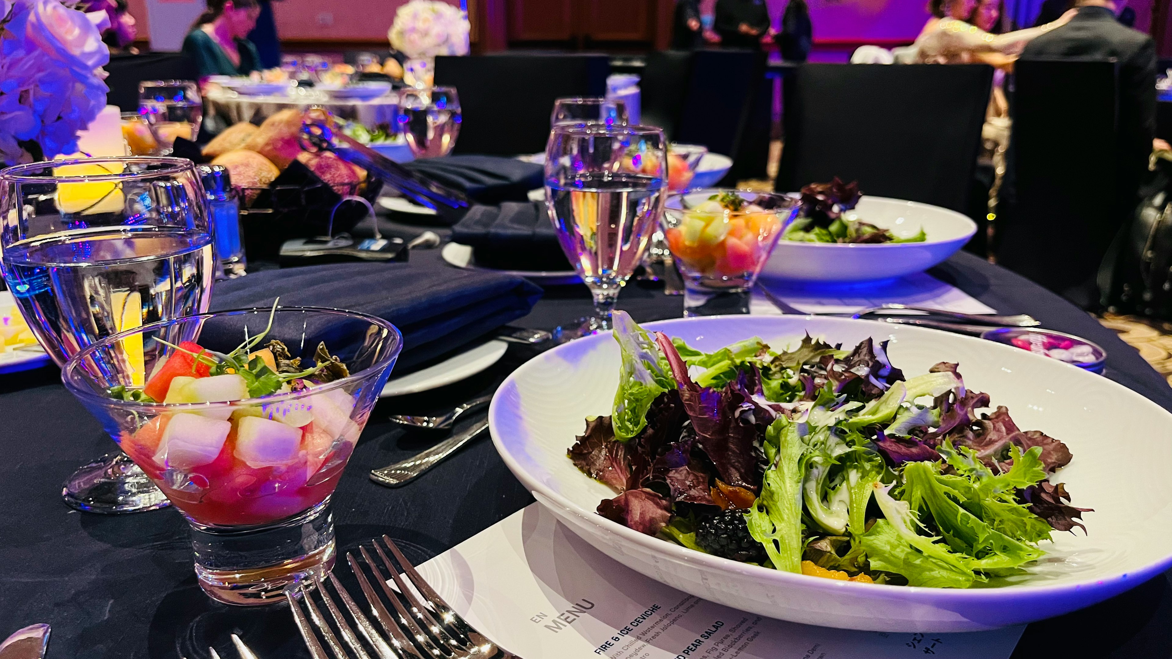 Configuración elegante de cena con ensalada y copa de frutas