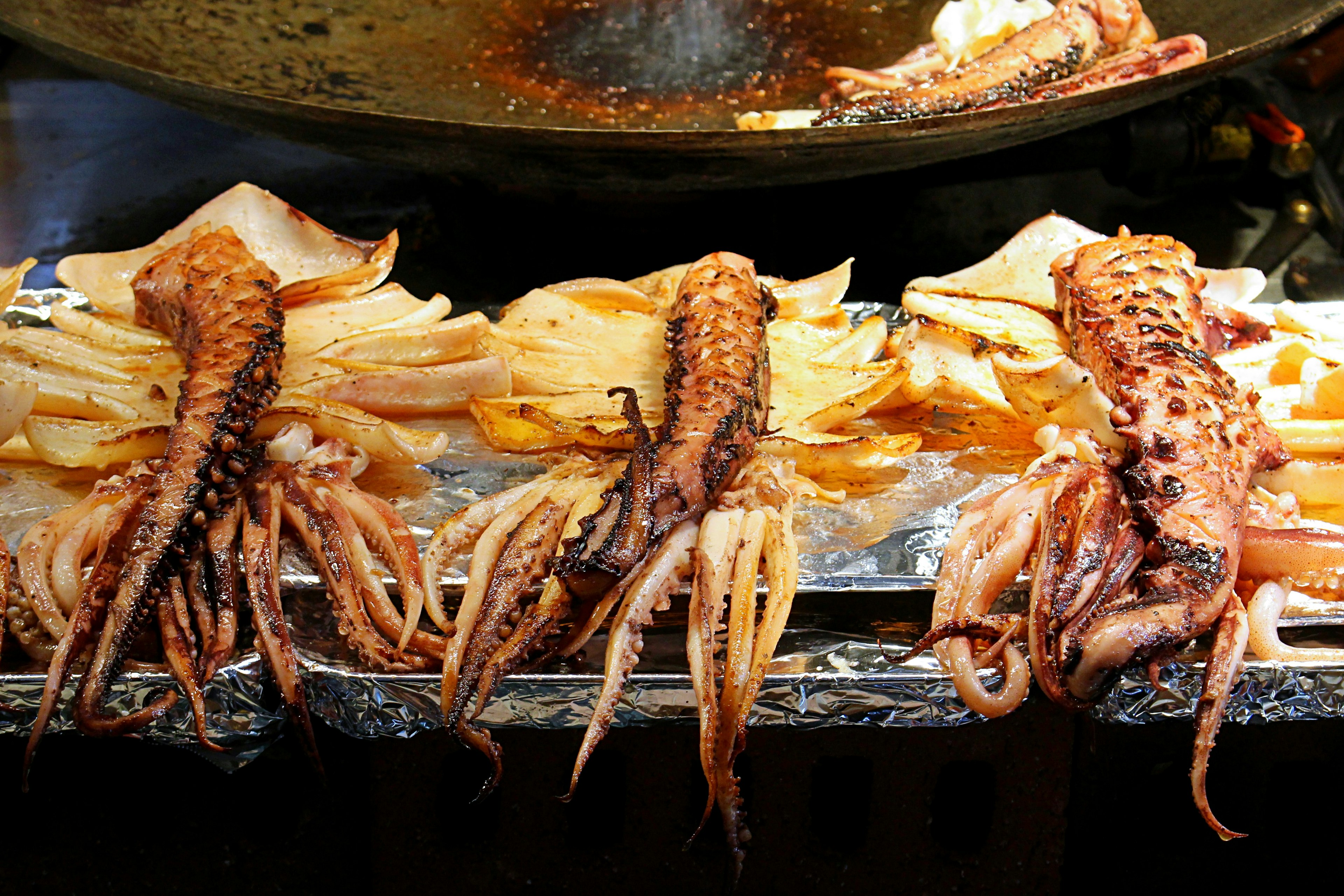 Calamares a la parrilla exhibidos en un puesto de comida callejera