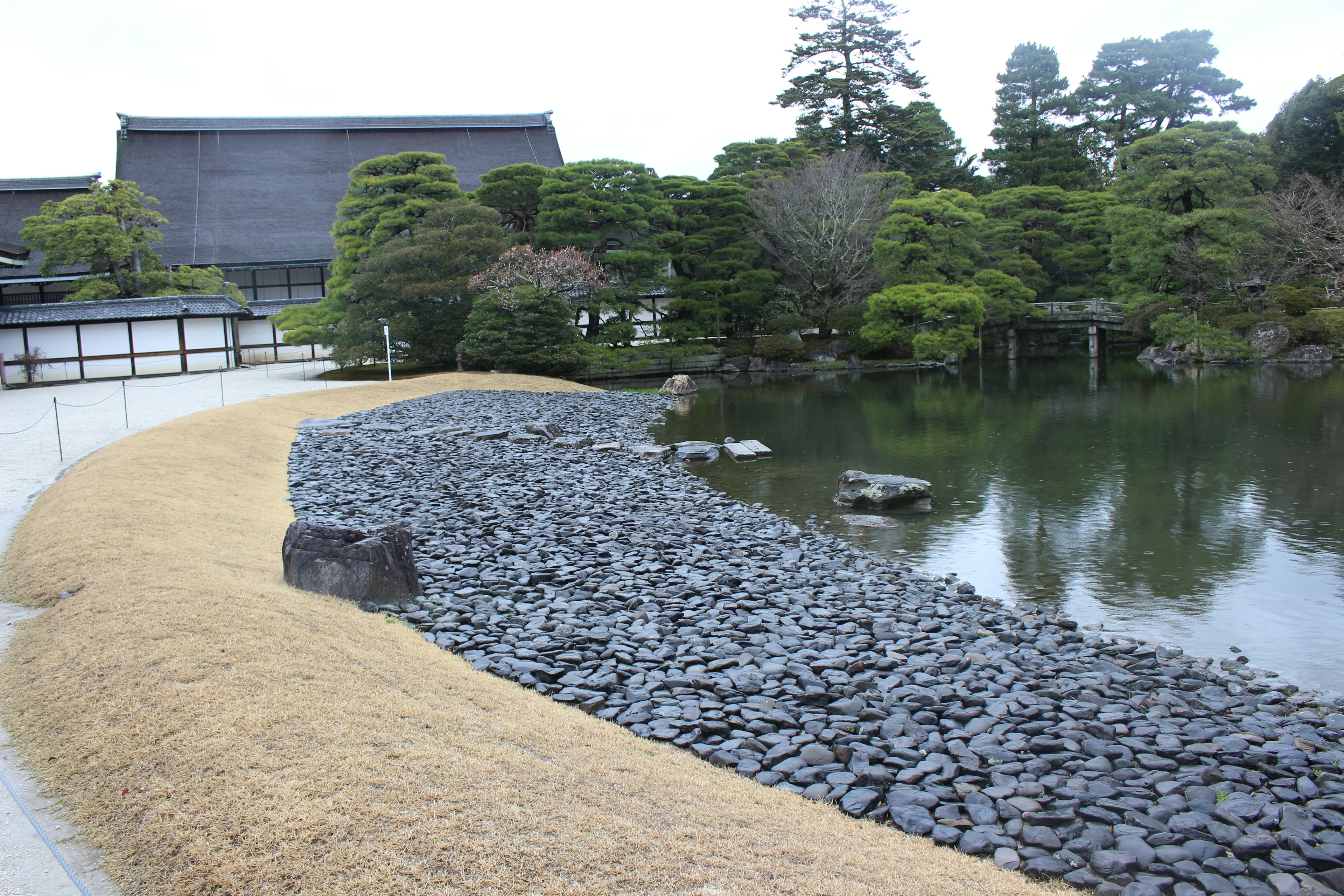 Ruhige japanische Gartenlandschaft mit Steinweg und üppigem Grün um einen Teich