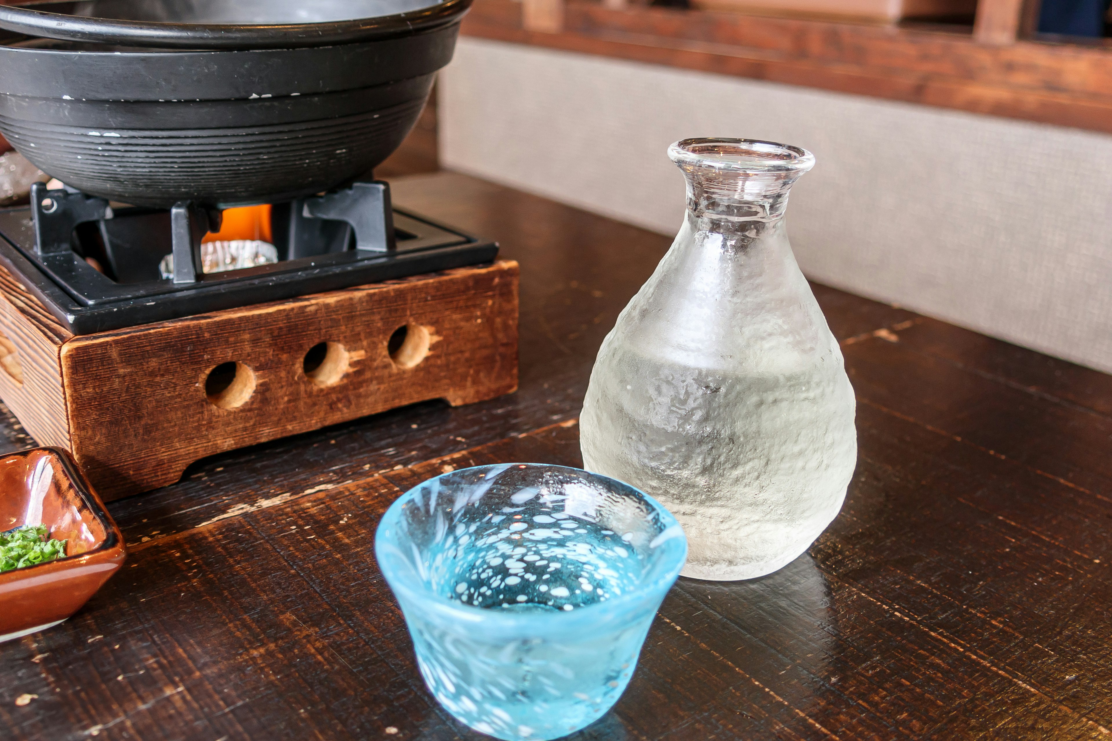 Configuración de mesa con una taza de vidrio azul y una botella clara