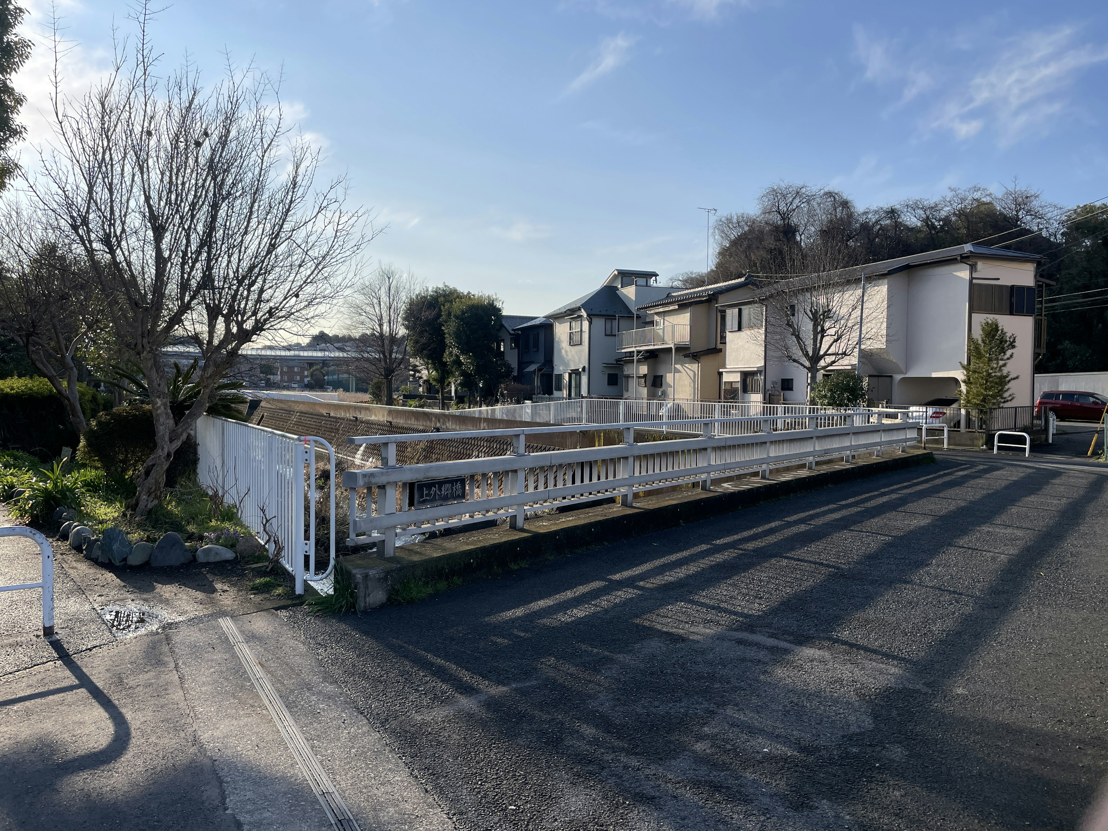 Vue d'un terrain vacant avec une clôture blanche dans un quartier résidentiel