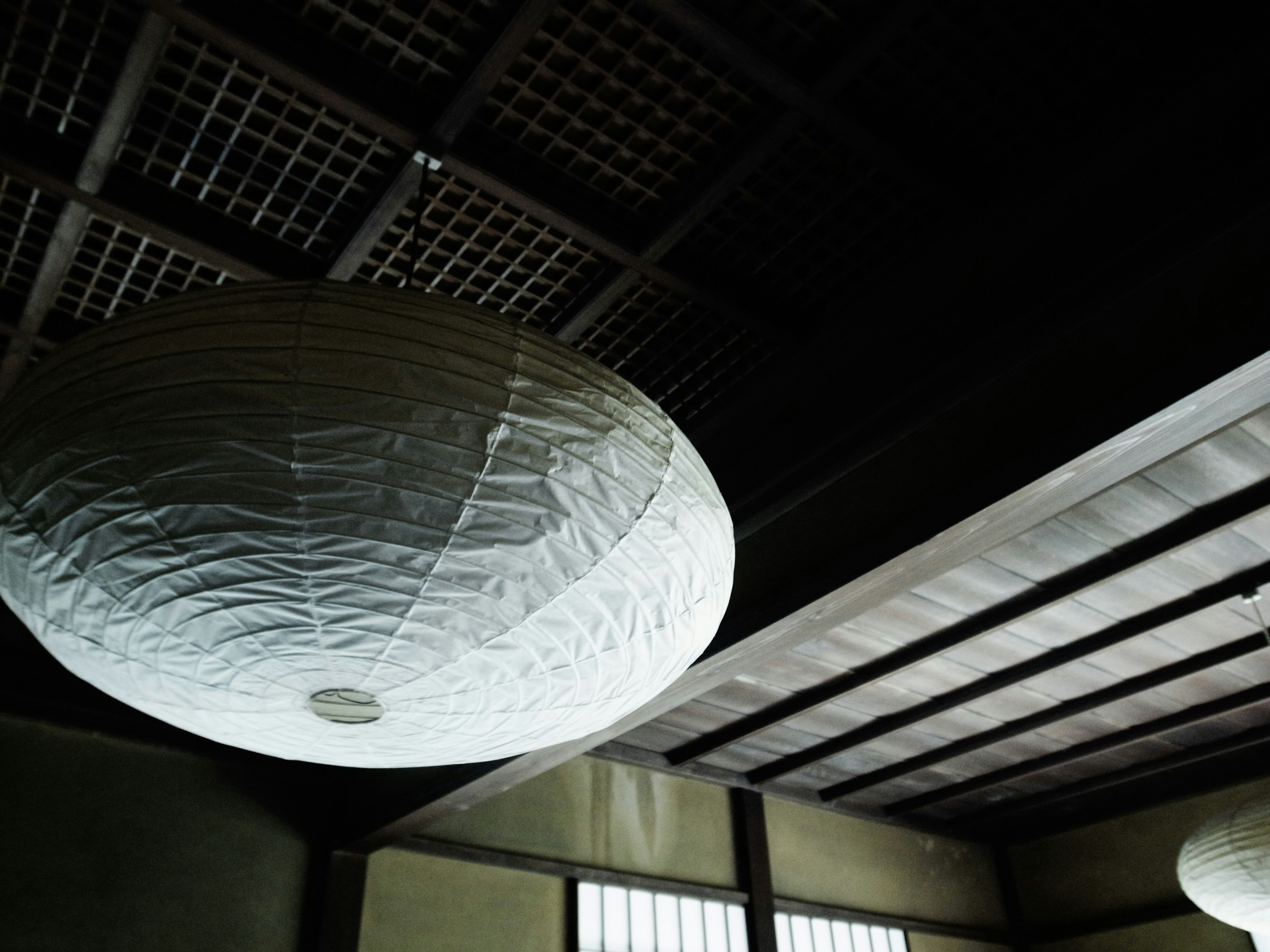 White Japanese-style light fixture hanging from the ceiling of a room