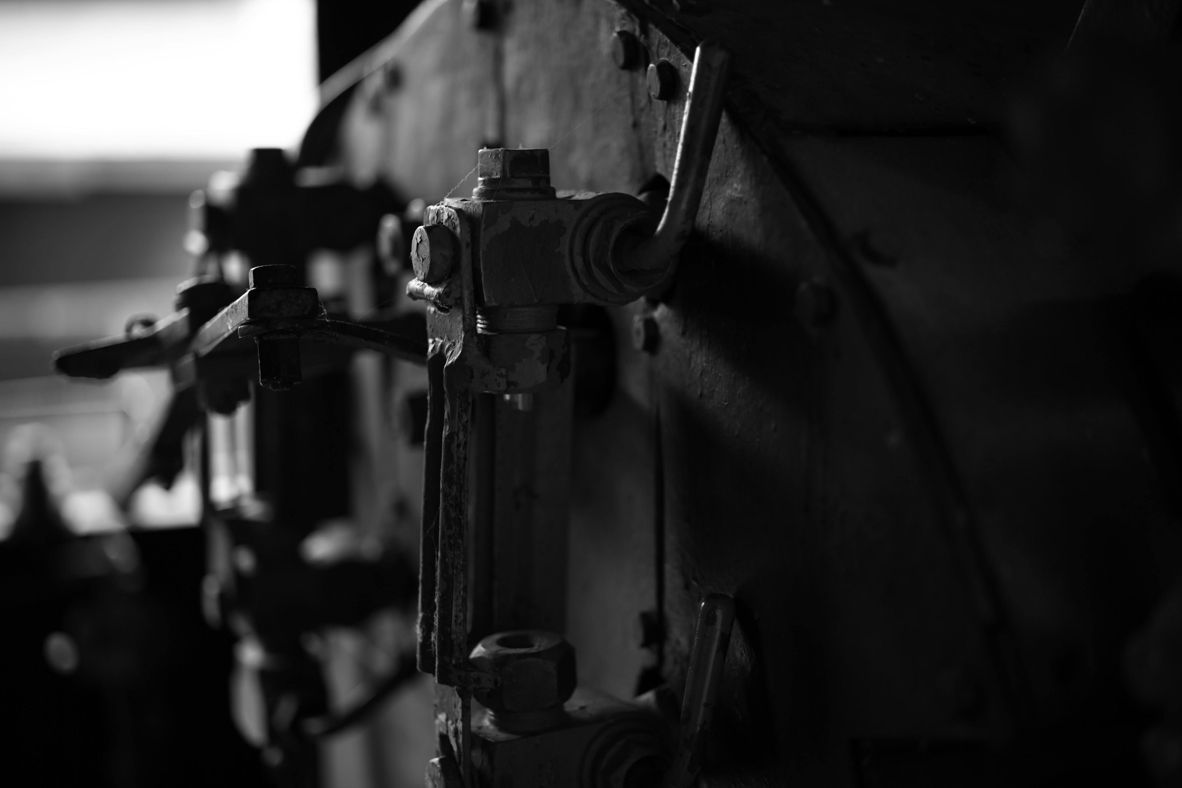 Close-up of black and white machinery parts featuring levers and valves