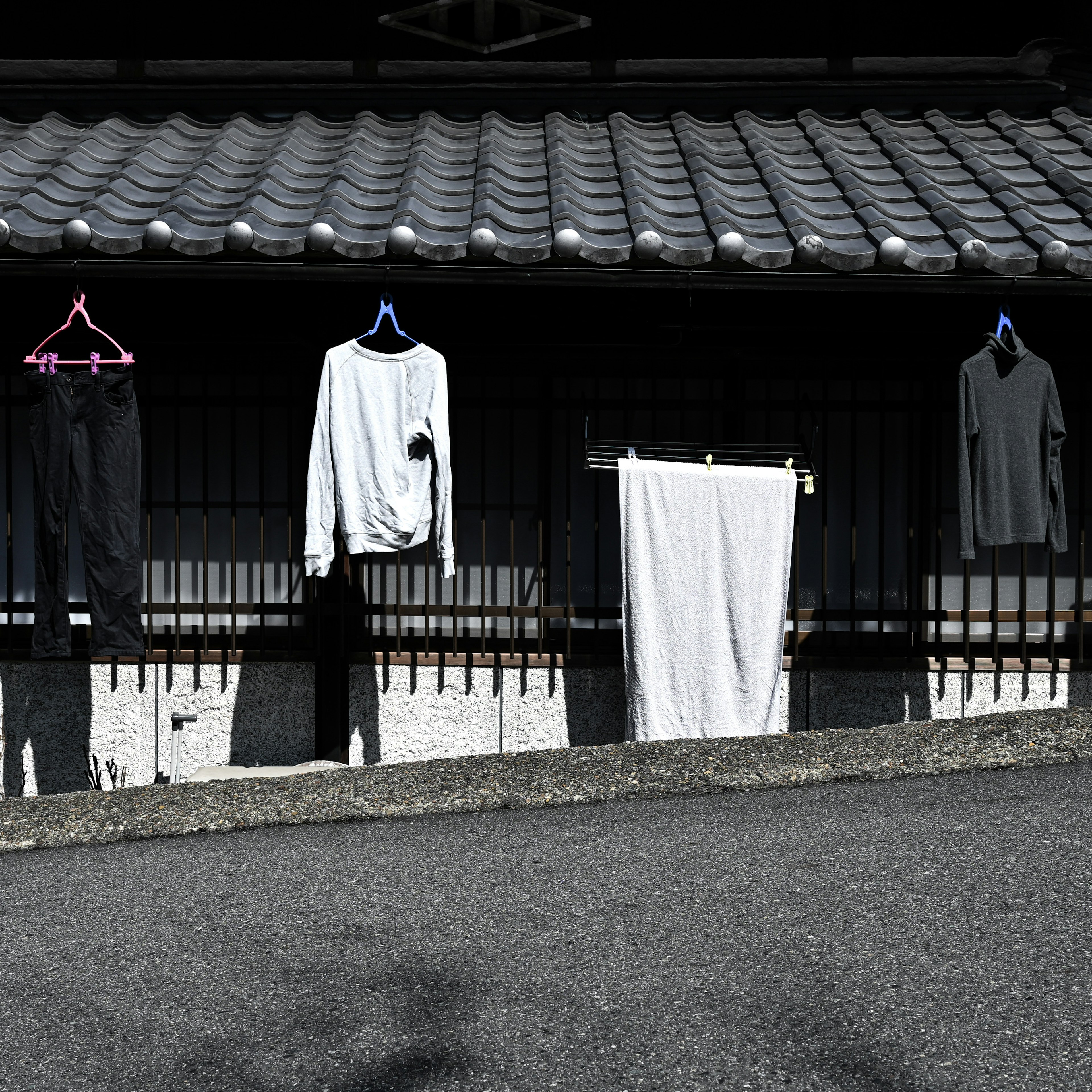 屋根の下に干された衣服とタオルが並ぶ景色