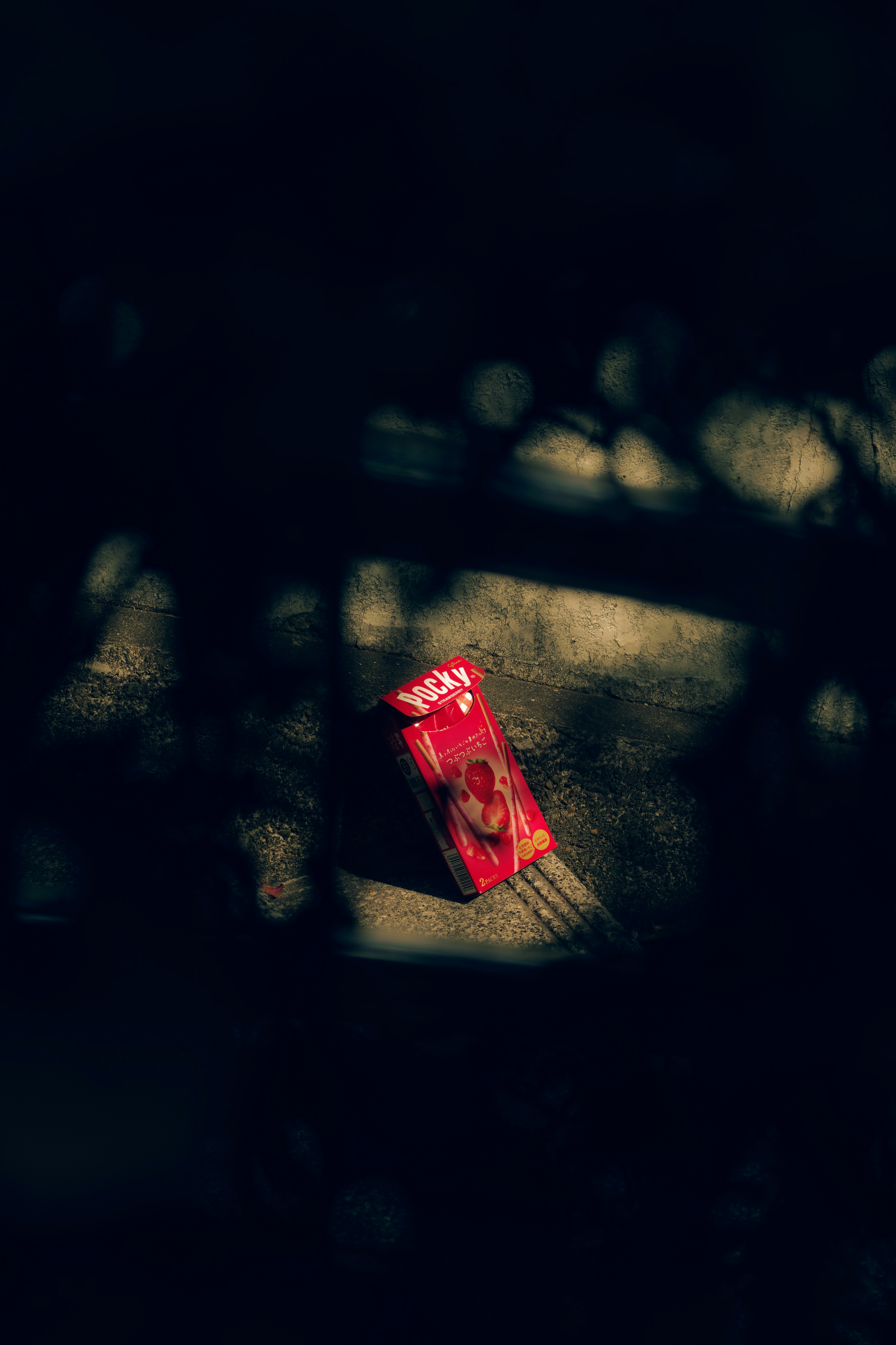 Un paquete de snack rojo colocado sobre un fondo oscuro