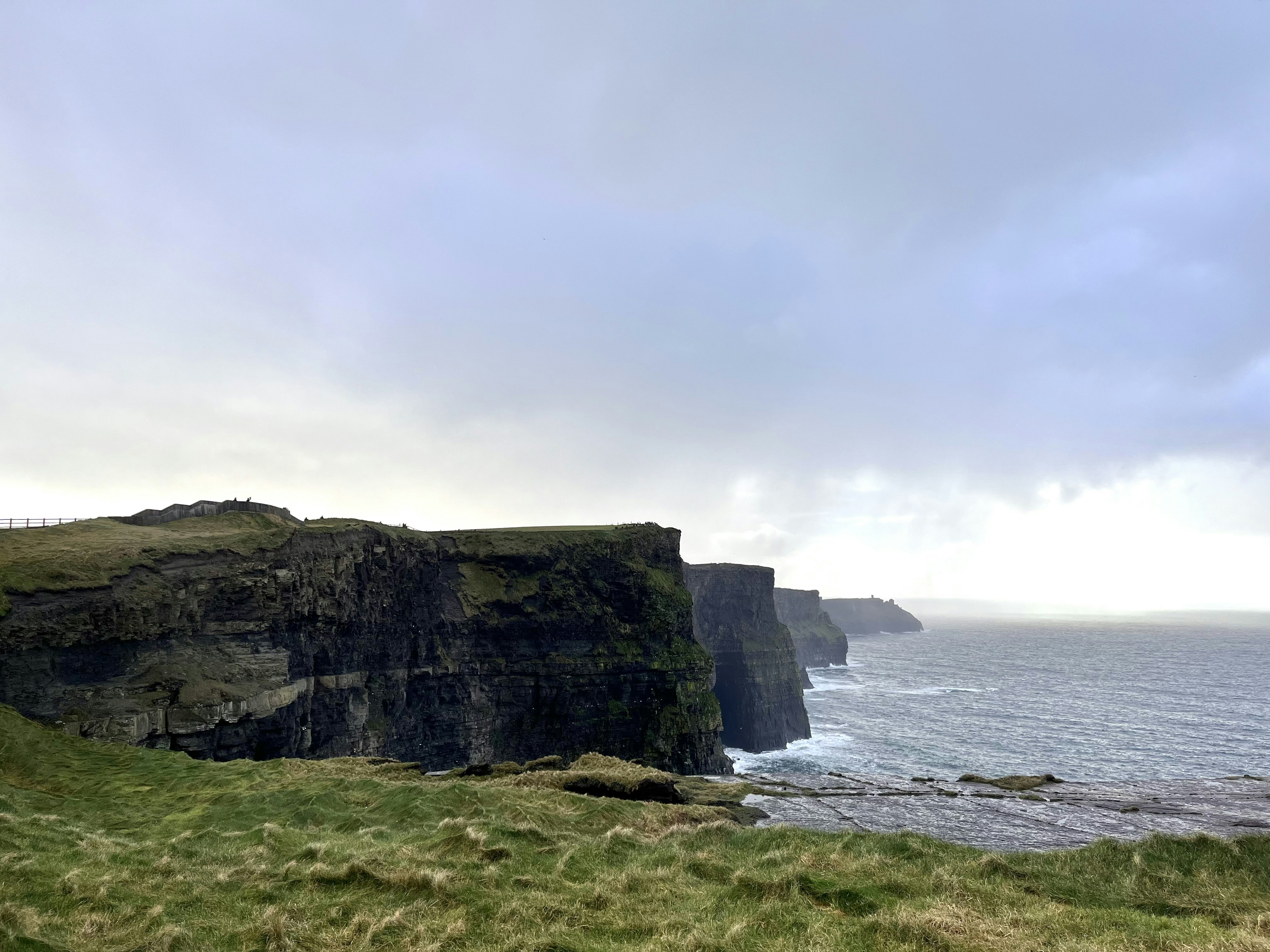 アイルランドの崖と海の景色 緑の草が広がる岸辺 雄大な雲が空を覆う