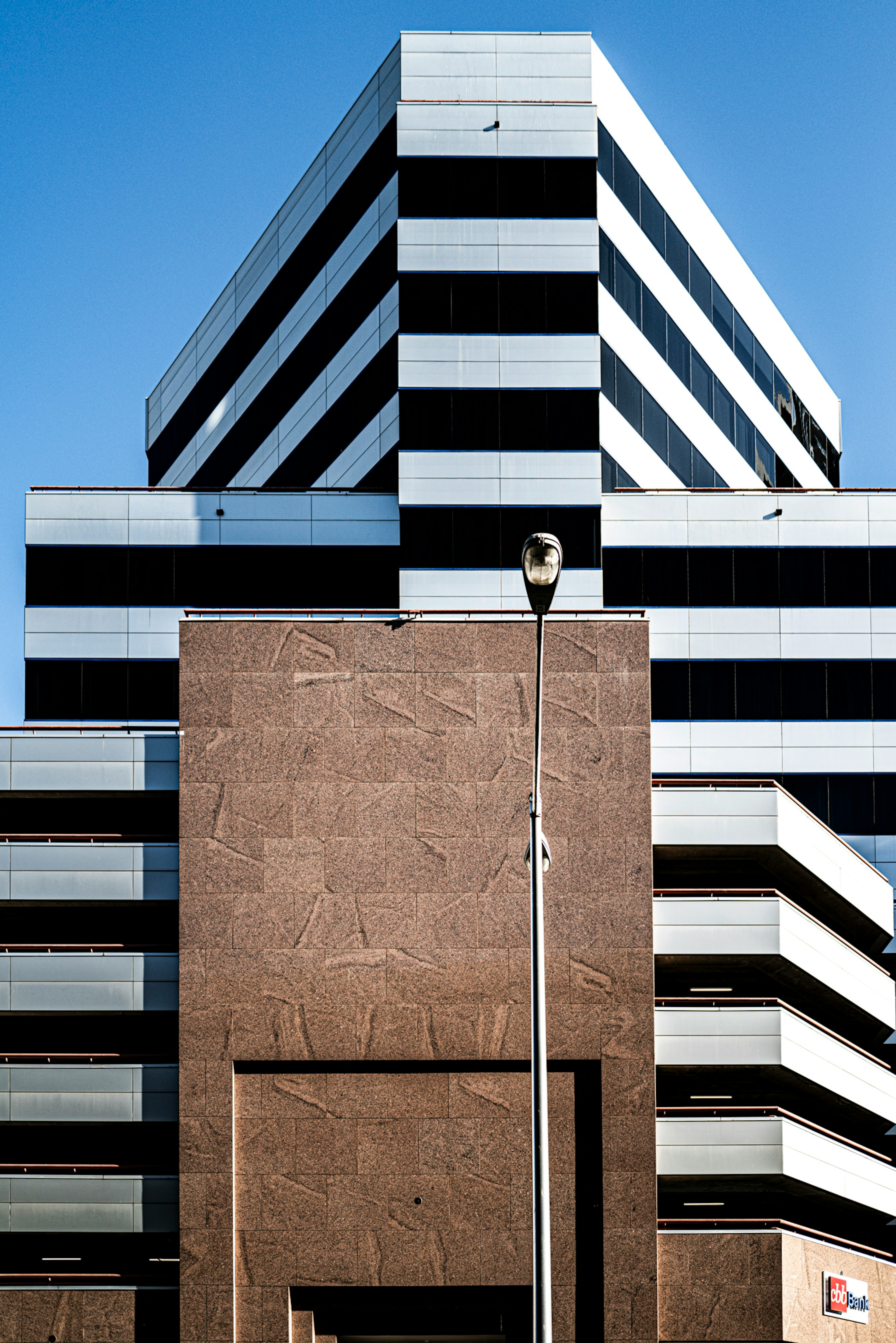 Fachada de edificio moderno con diseño estructural que presenta rayas grises y negras