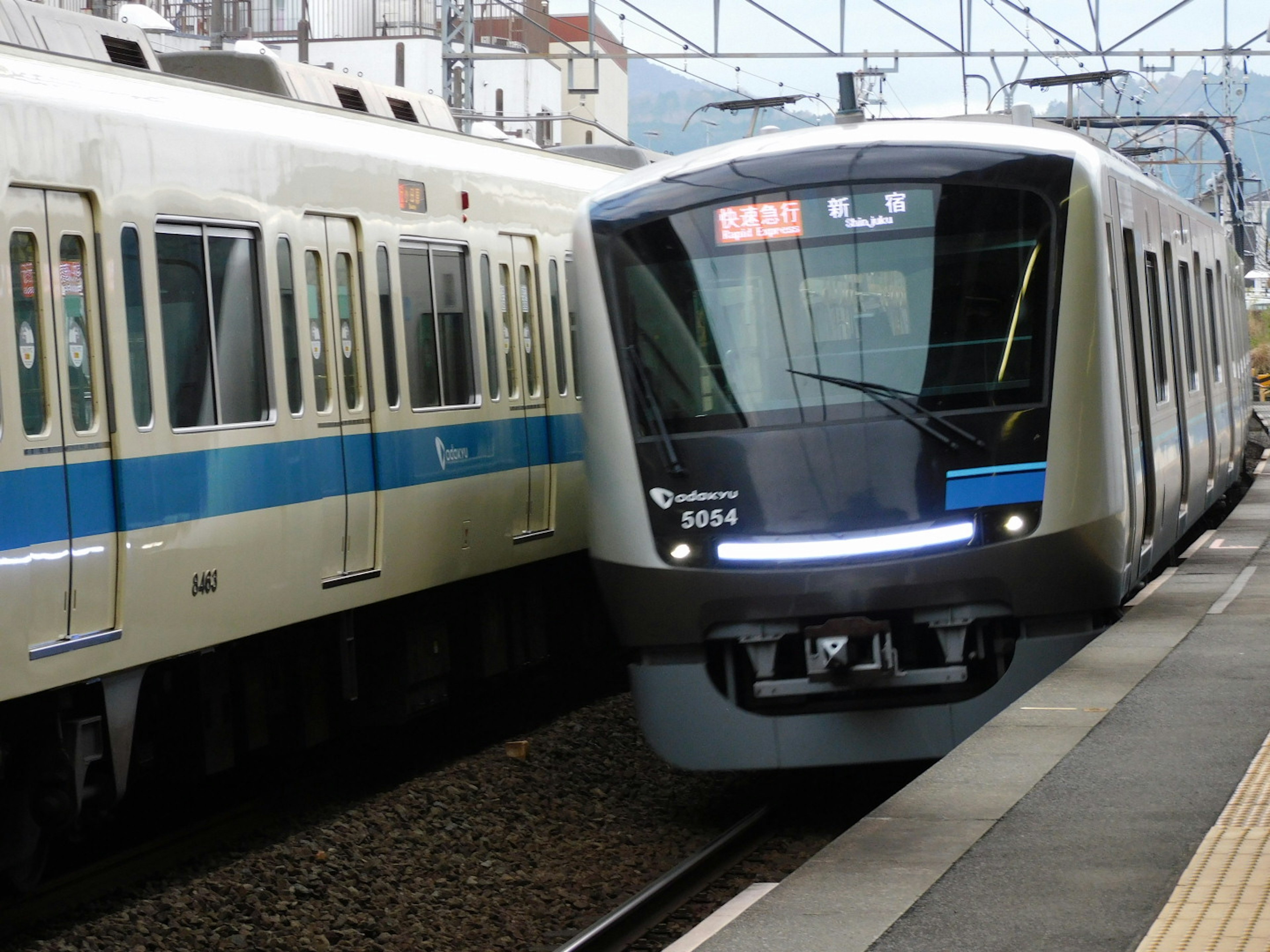 Dos trenes en una estación uno con diseño moderno