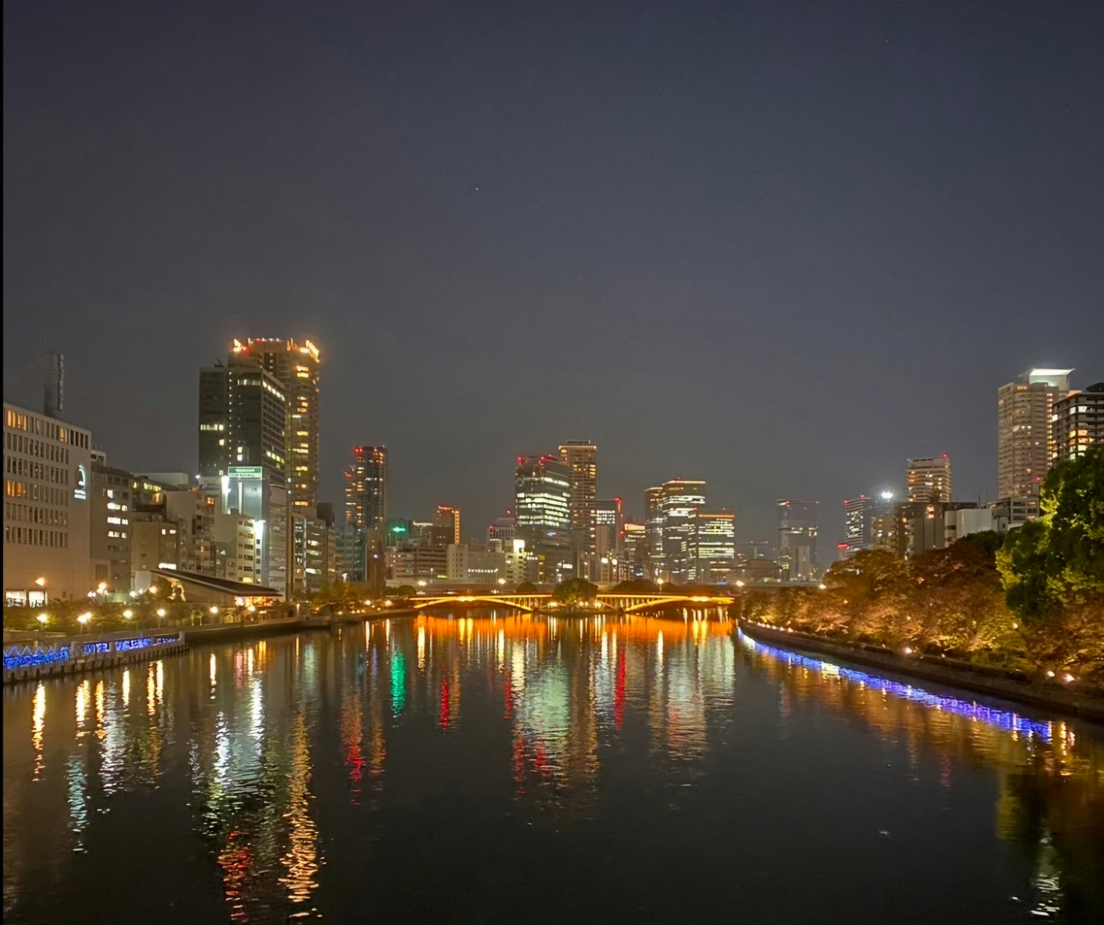 Bellissimo paesaggio urbano notturno con riflessi sul fiume