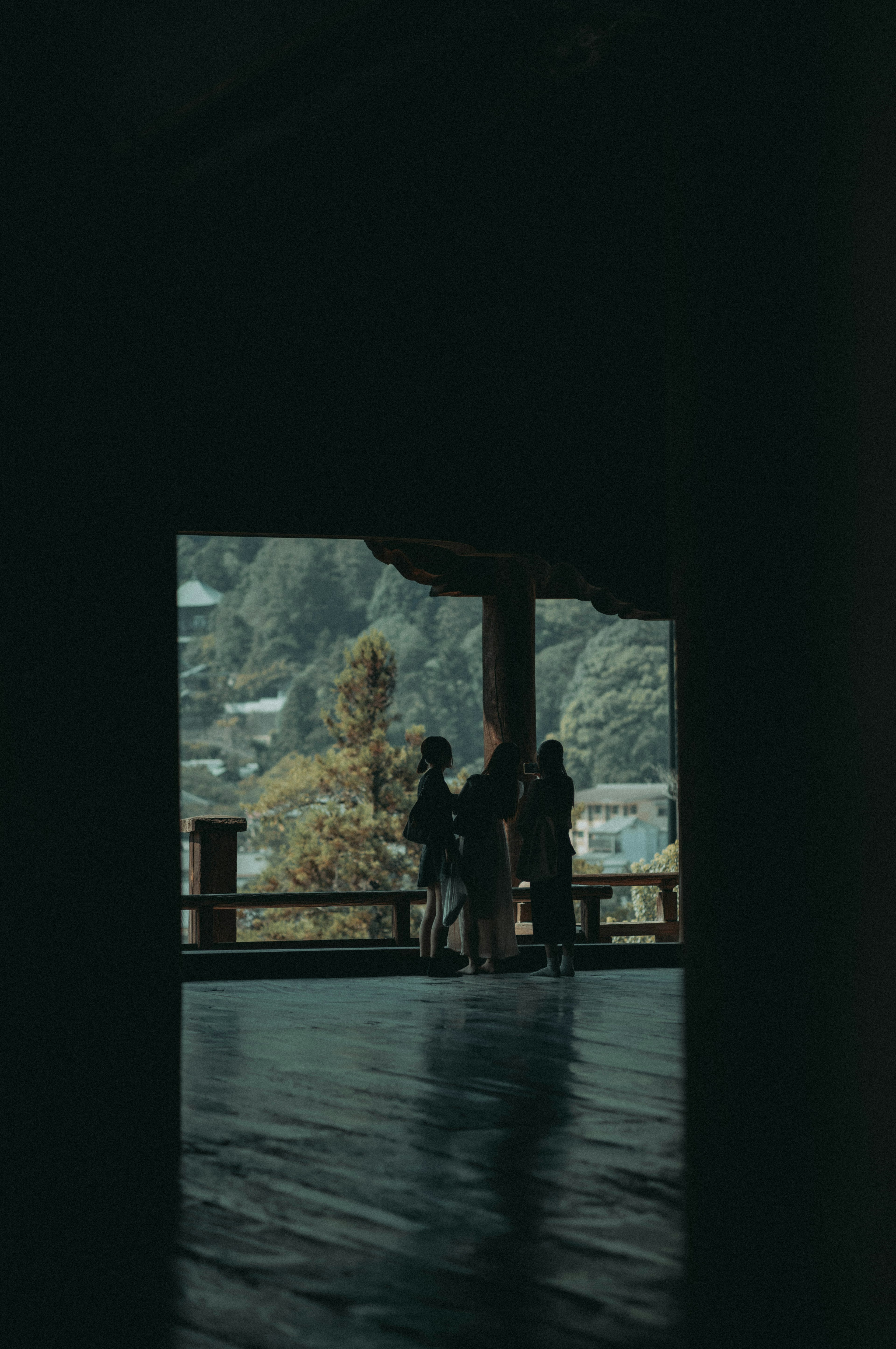 Silhouetten von Menschen in einem Holzgebäude mit Blick auf die Natur