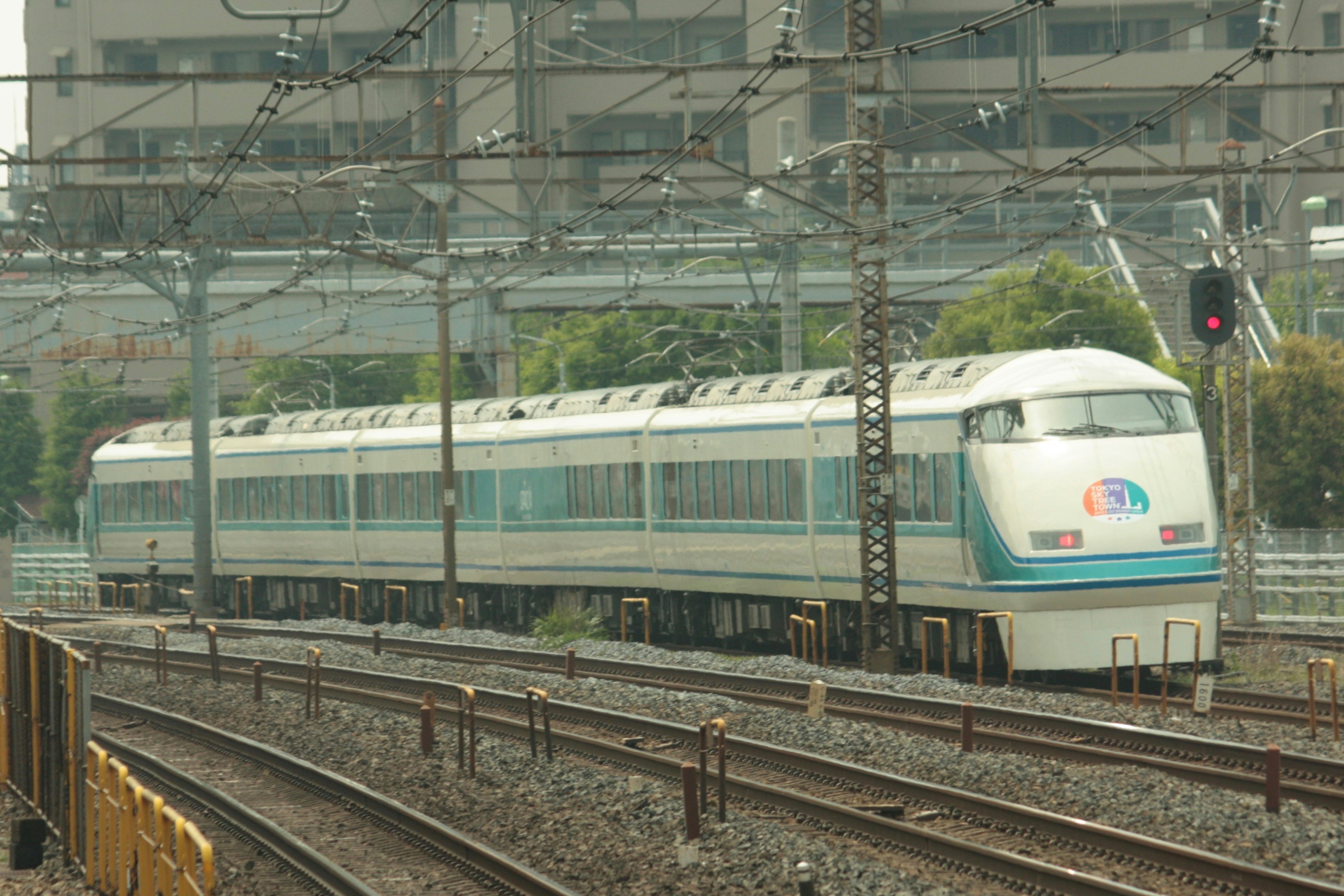 青い帯のある近代的な列車が鉄道を走る