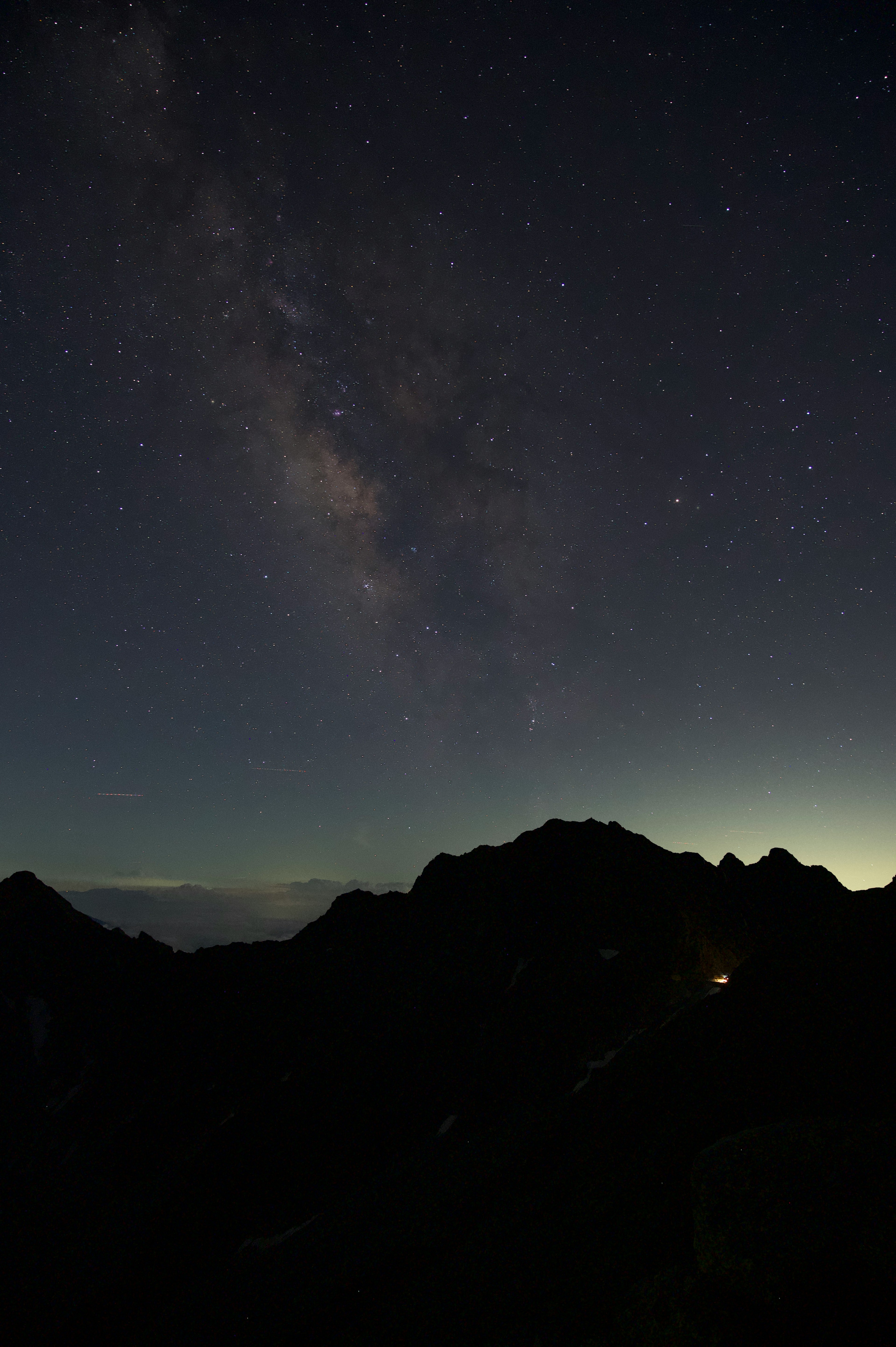 Vista mozzafiato delle montagne sotto un cielo stellato con la Via Lattea