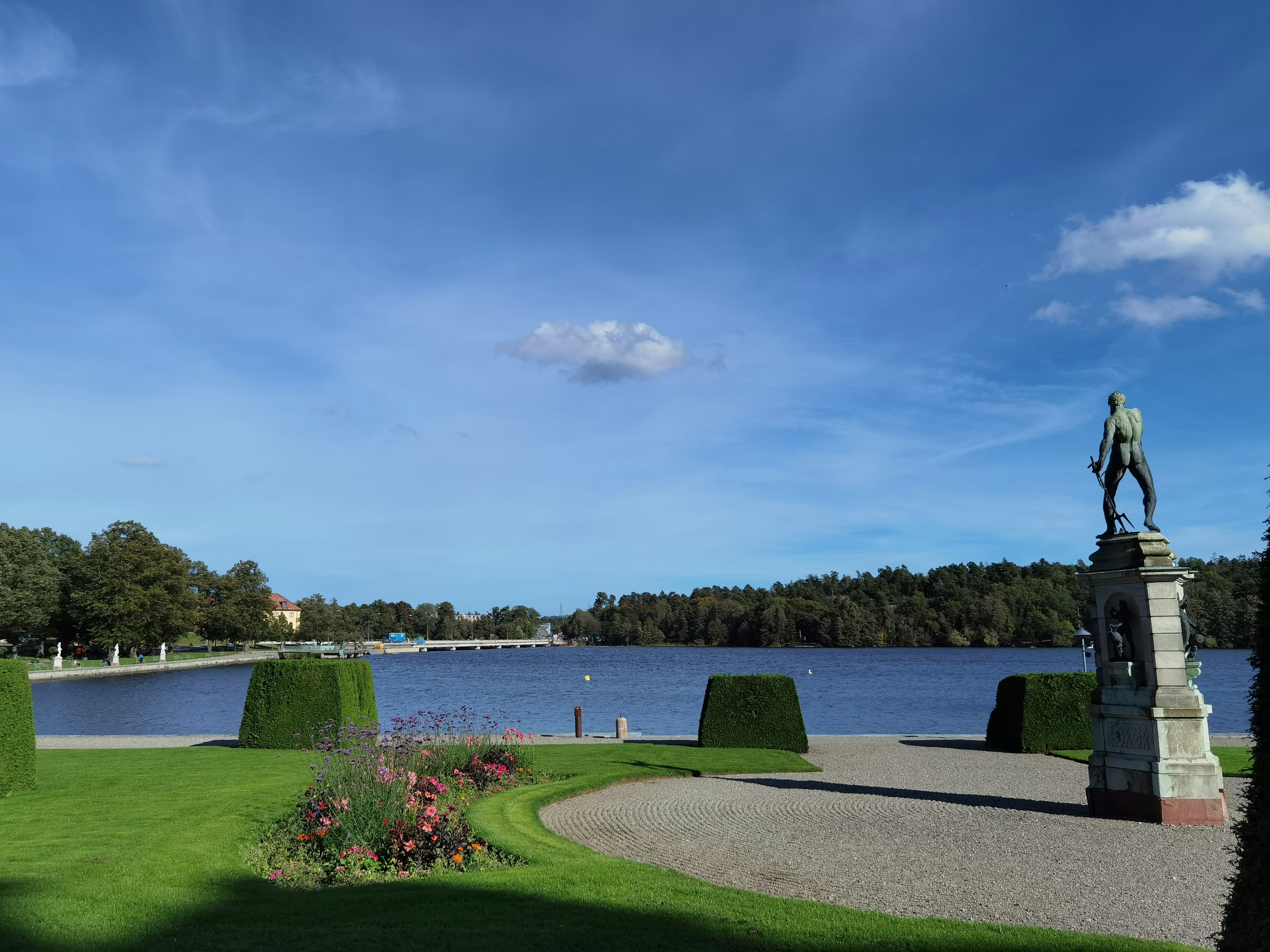 Vista panoramica di un lago con una statua e cielo blu