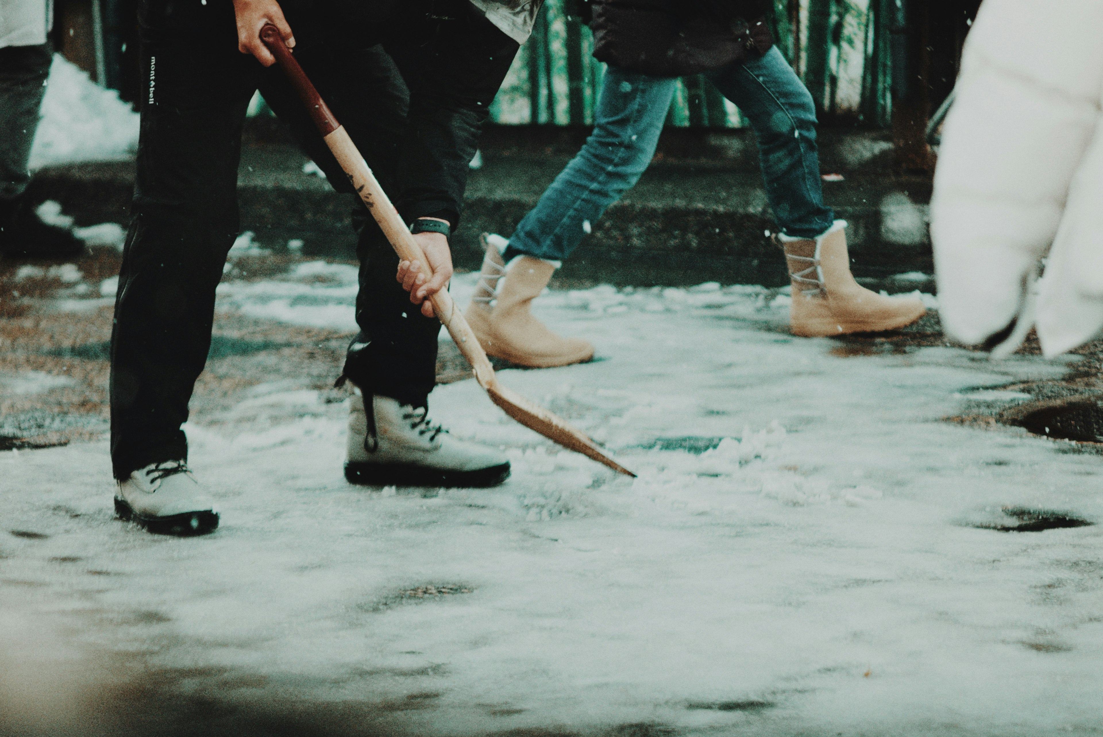 People walking in the snow using a shovel