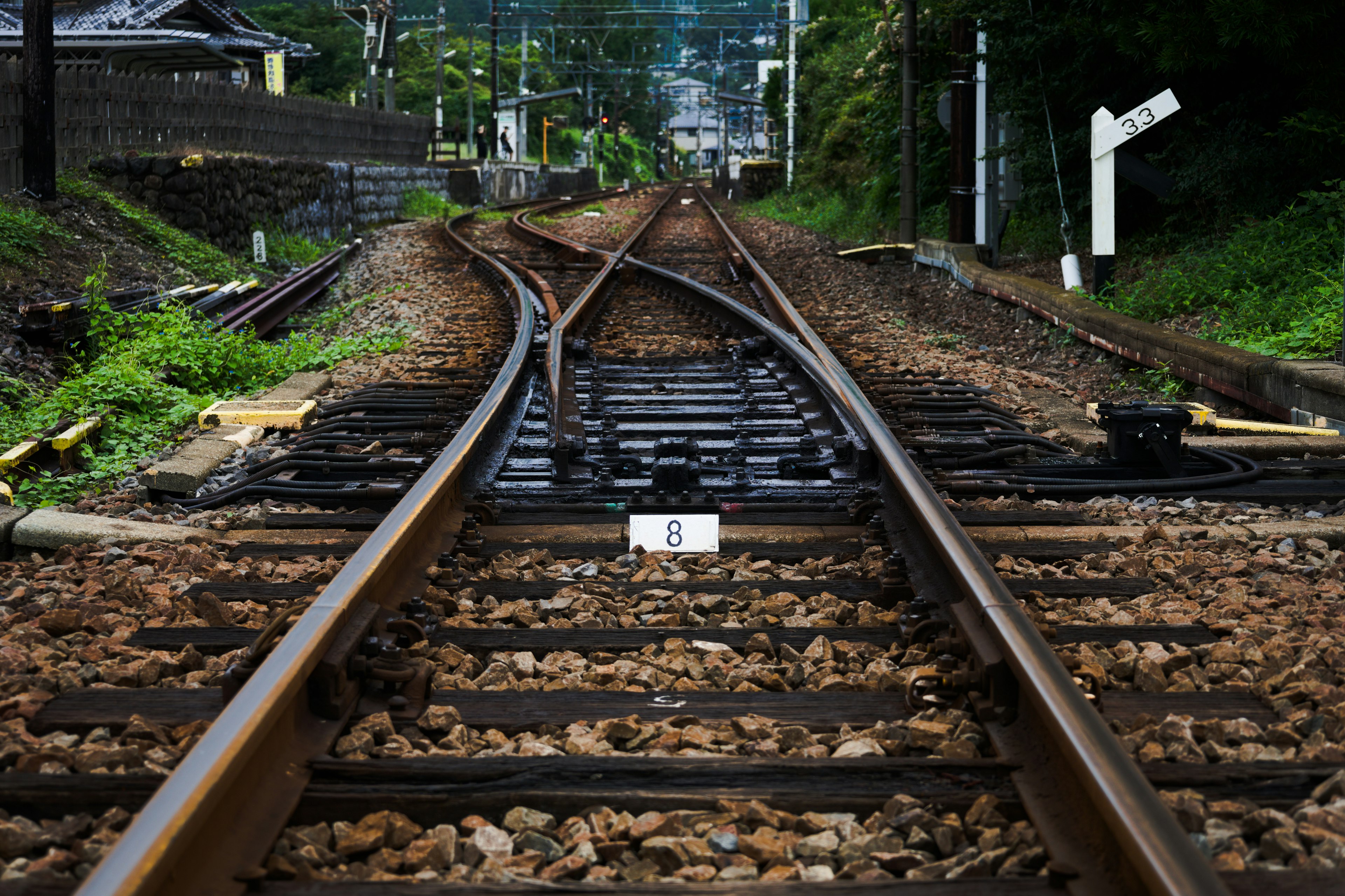 Primo piano di un incrocio ferroviario con dettagli dei binari e ghiaia