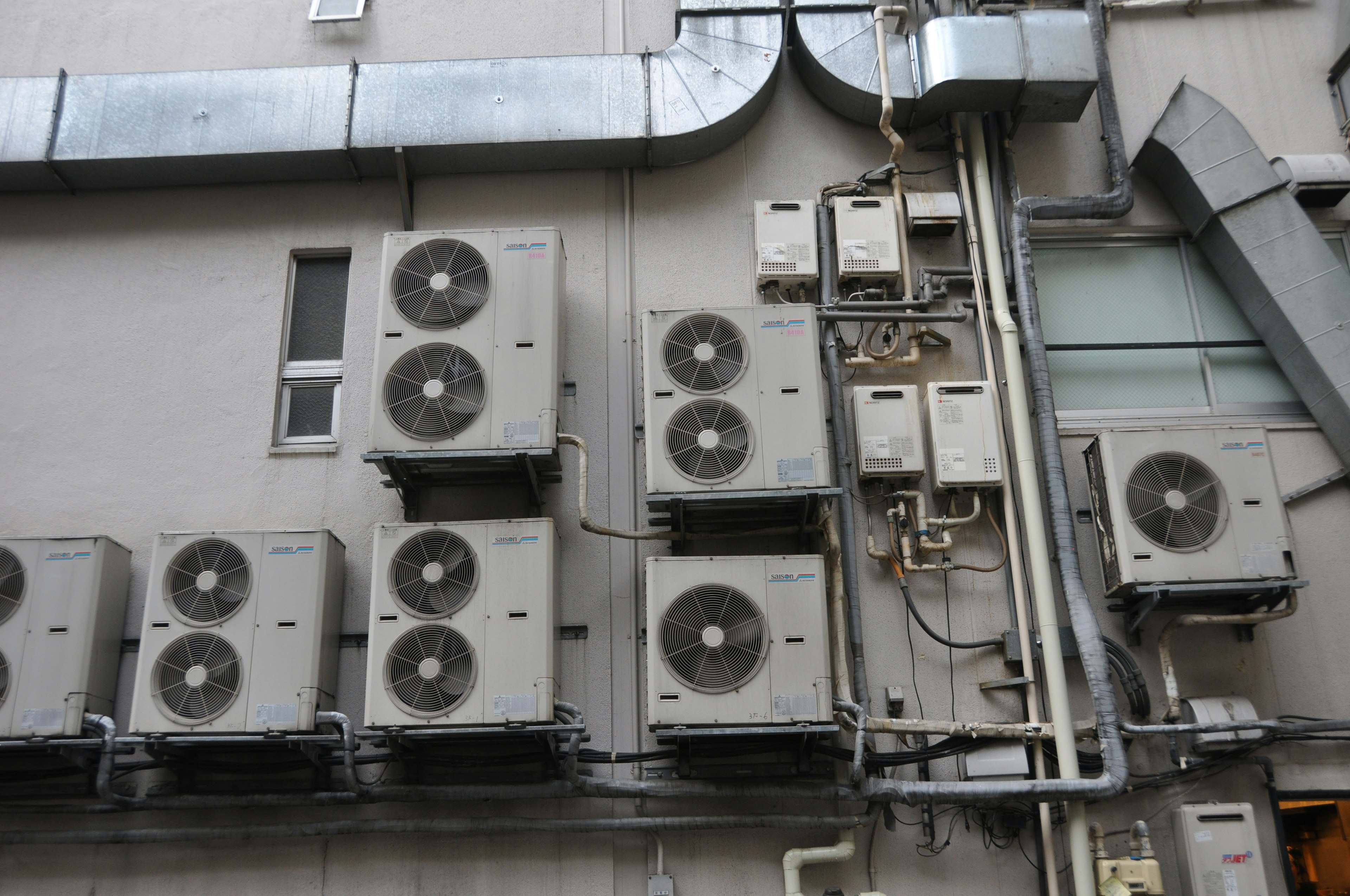 Multiple air conditioning units mounted on a building's exterior wall