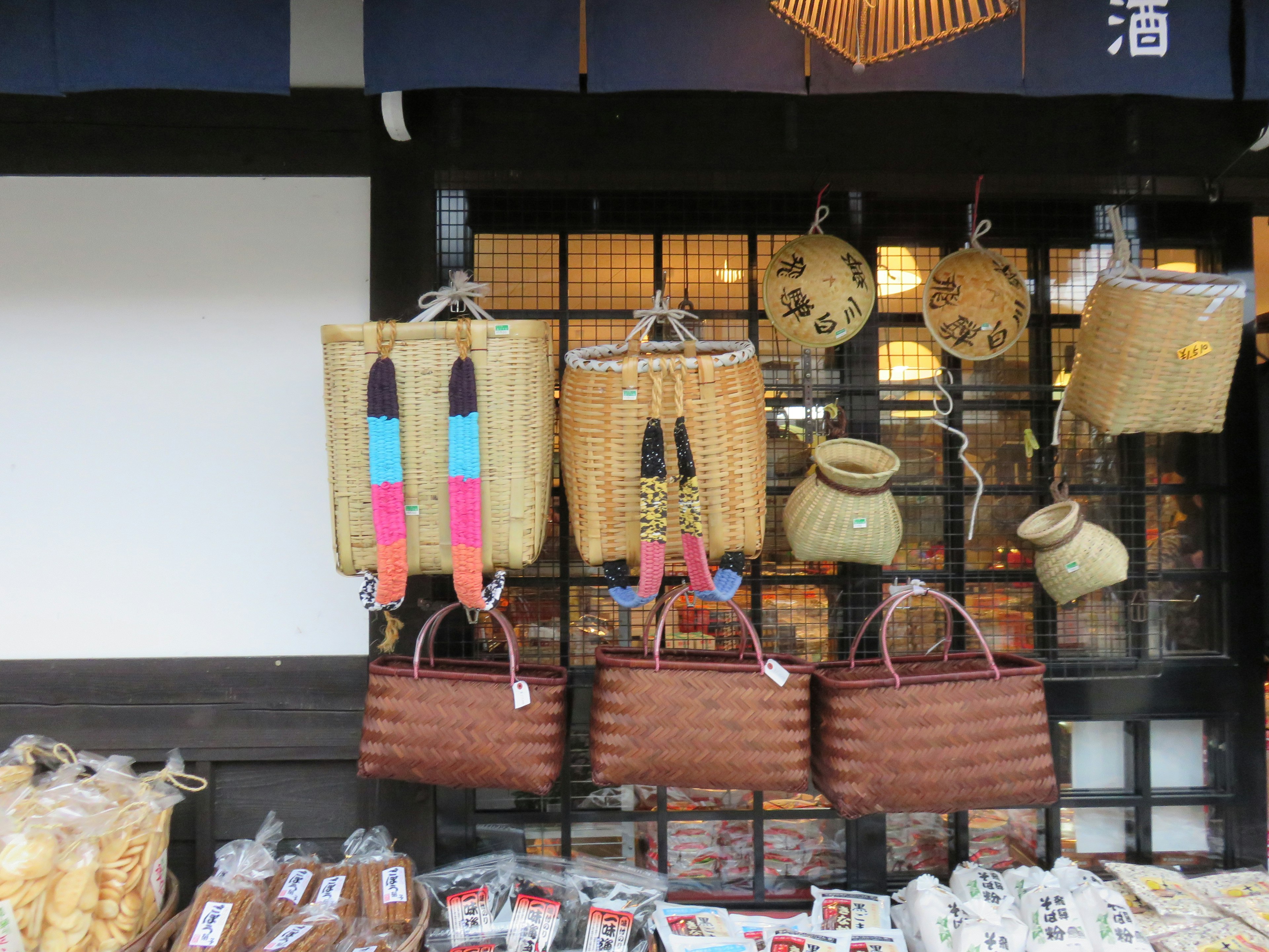 Exterior de una tienda japonesa tradicional que exhibe cestas y bolsas coloridas