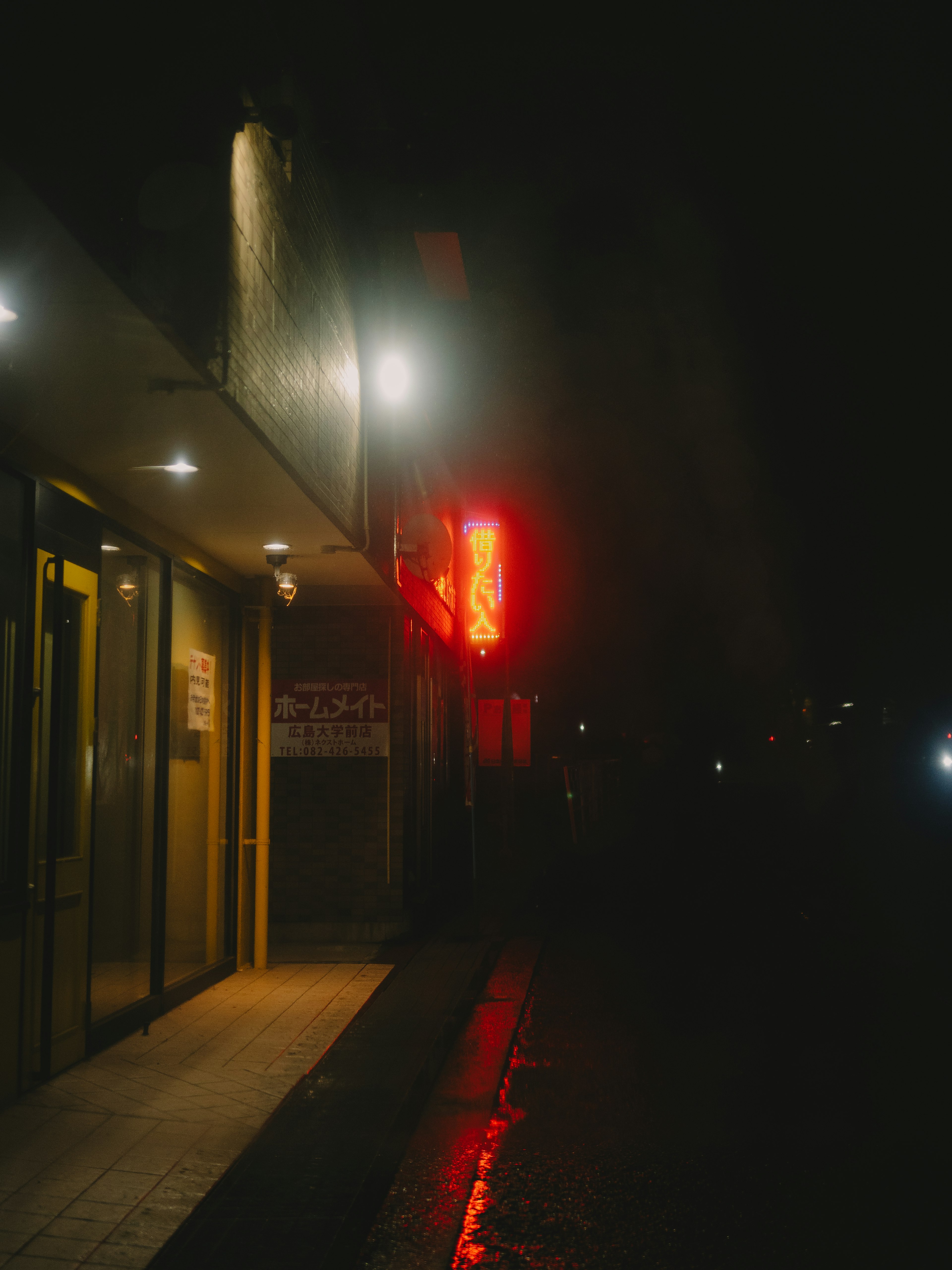 Store entrance with bright red sign at night