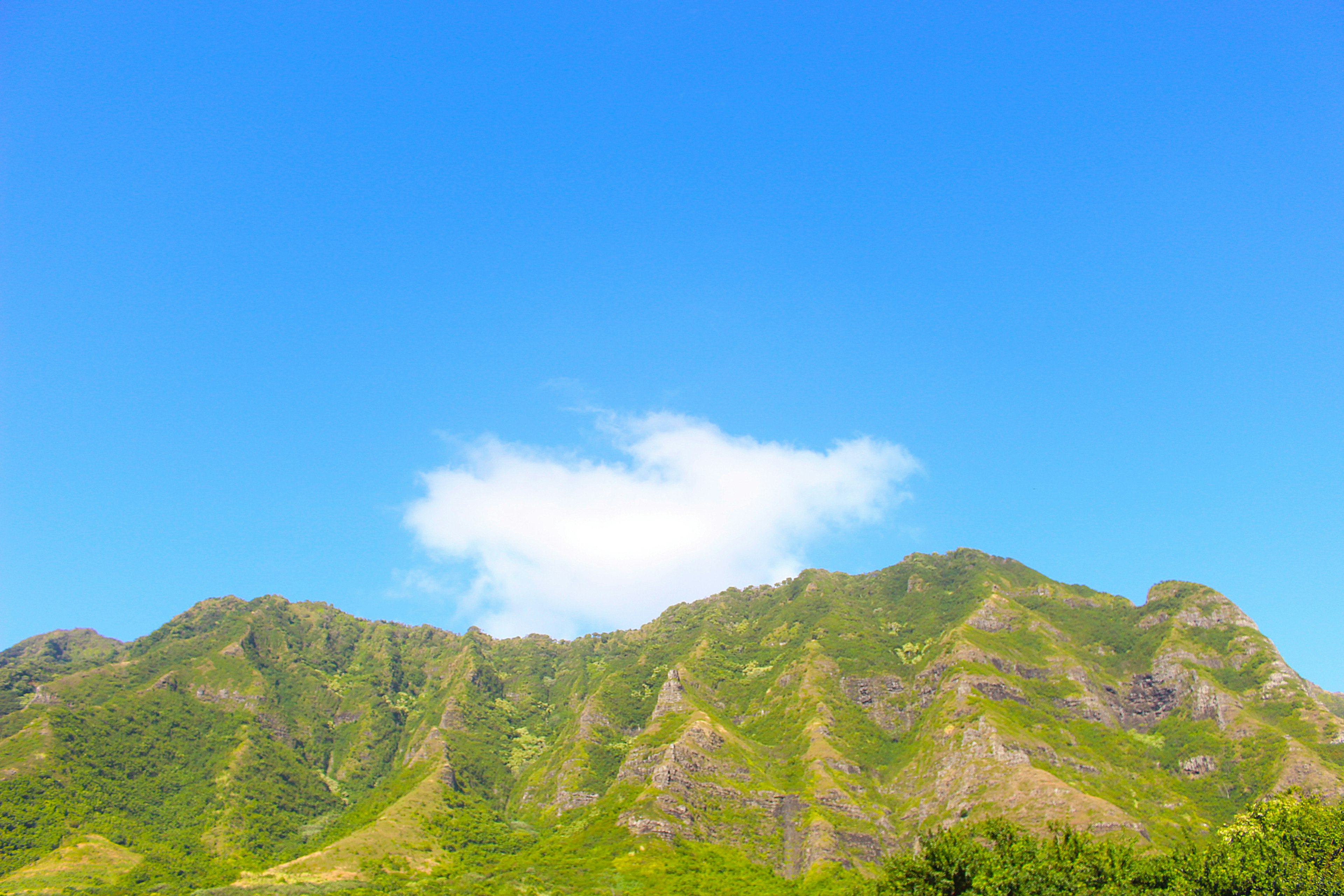 Pemandangan indah pegunungan hijau di bawah langit biru cerah