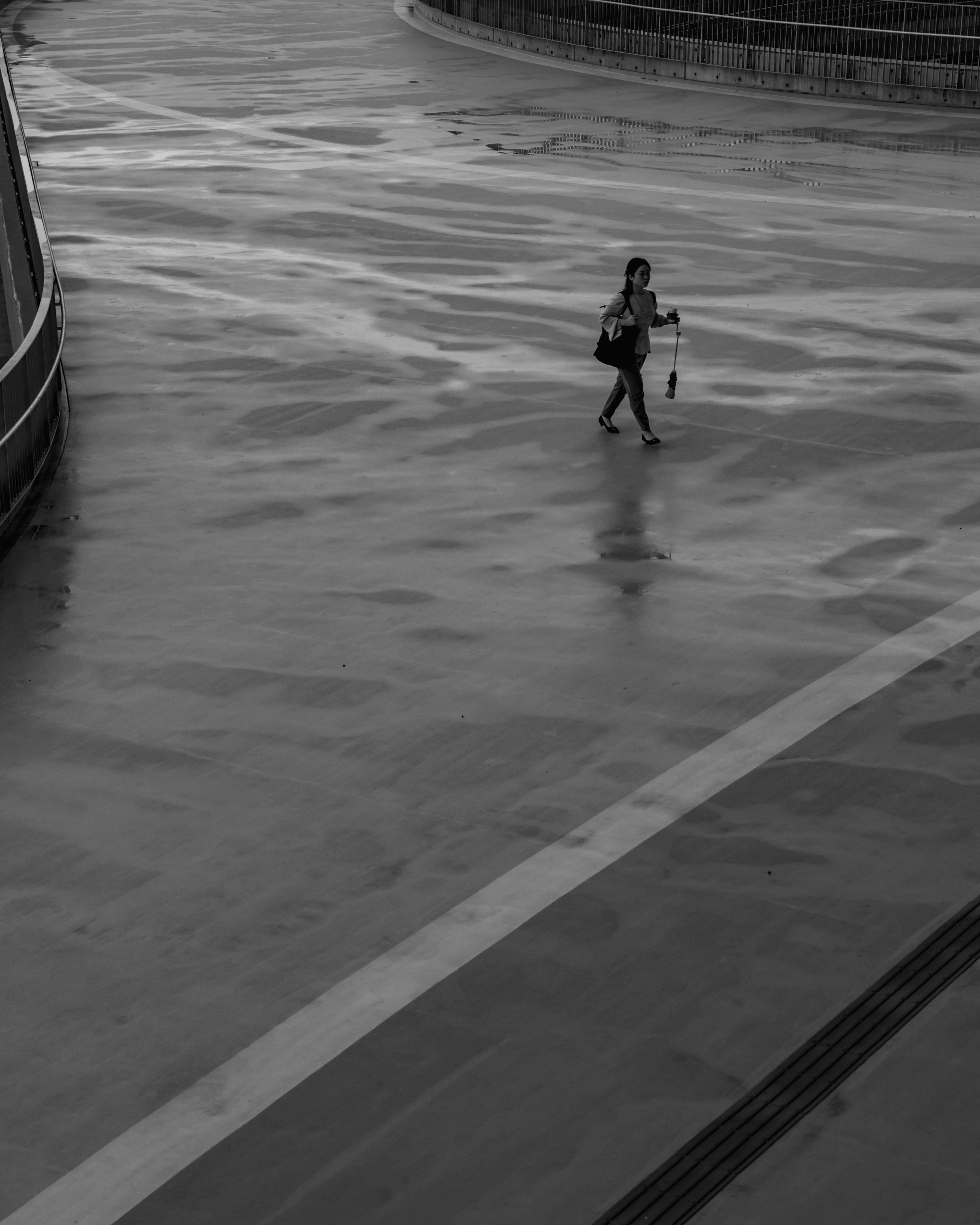 Une personne marchant avec un parapluie sur une surface mouillée