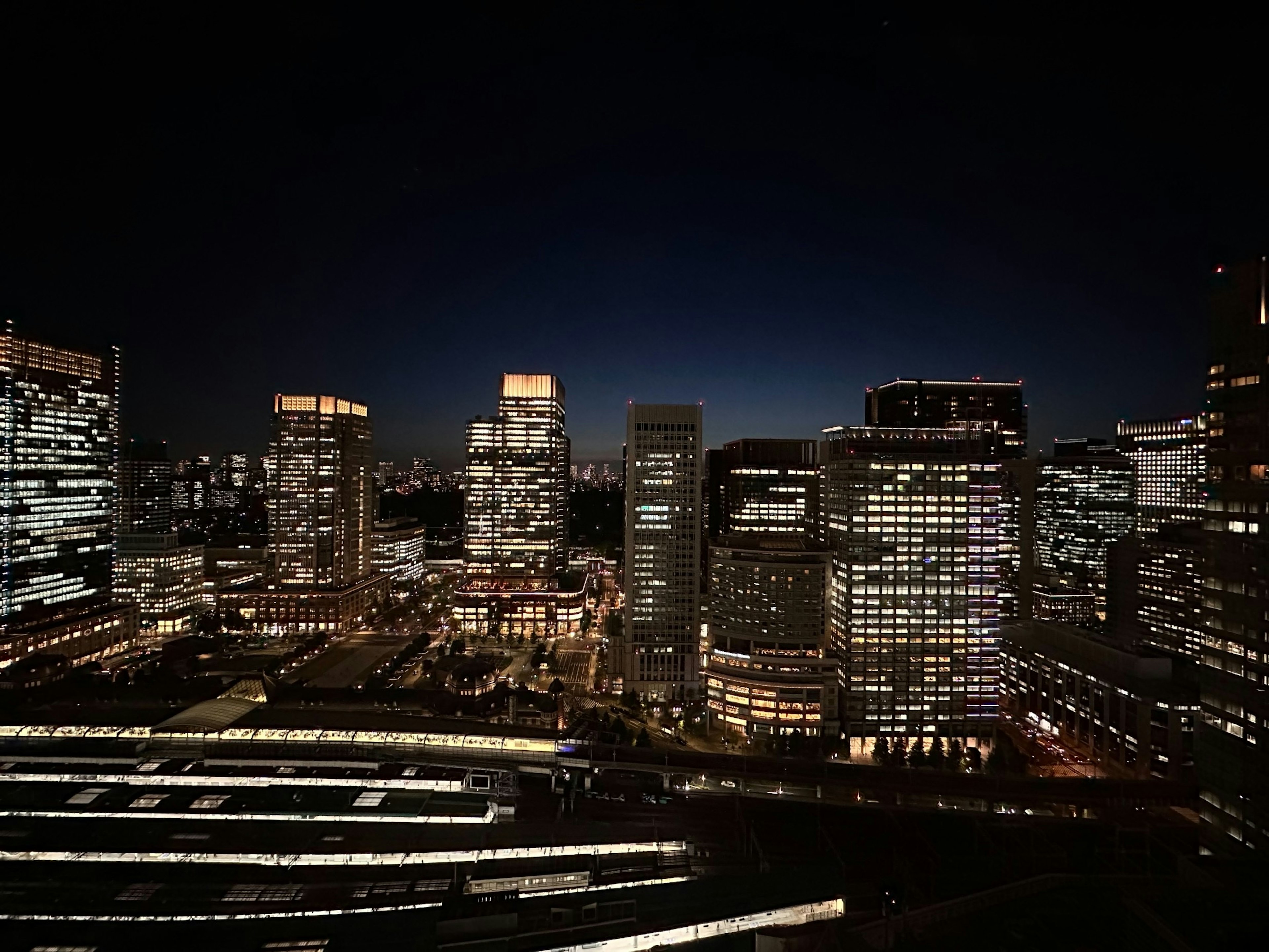 Paysage urbain nocturne avec gratte-ciels lumineux et ciel sombre