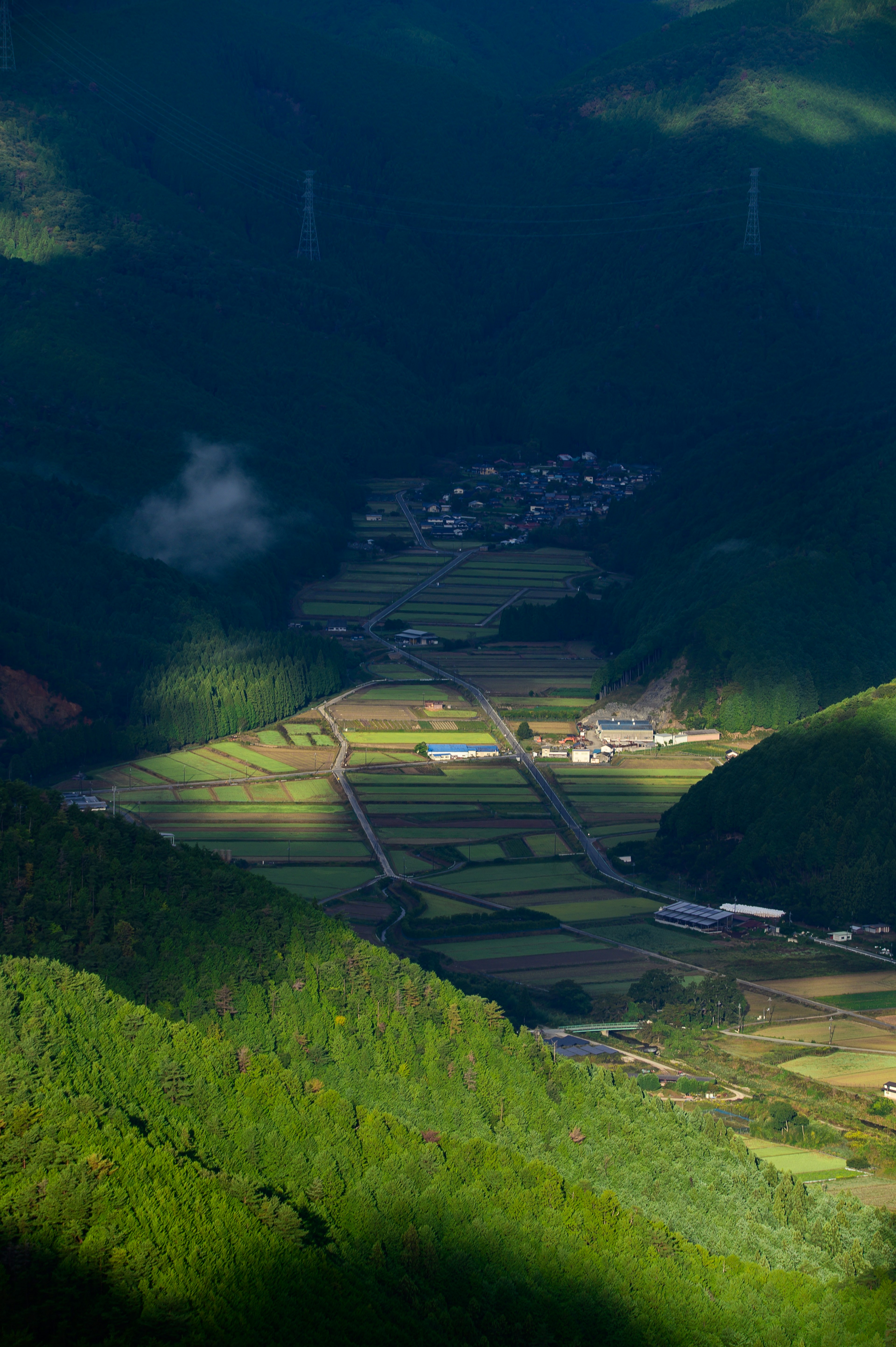 Beautiful valley landscape surrounded by mountains with green fields and a village