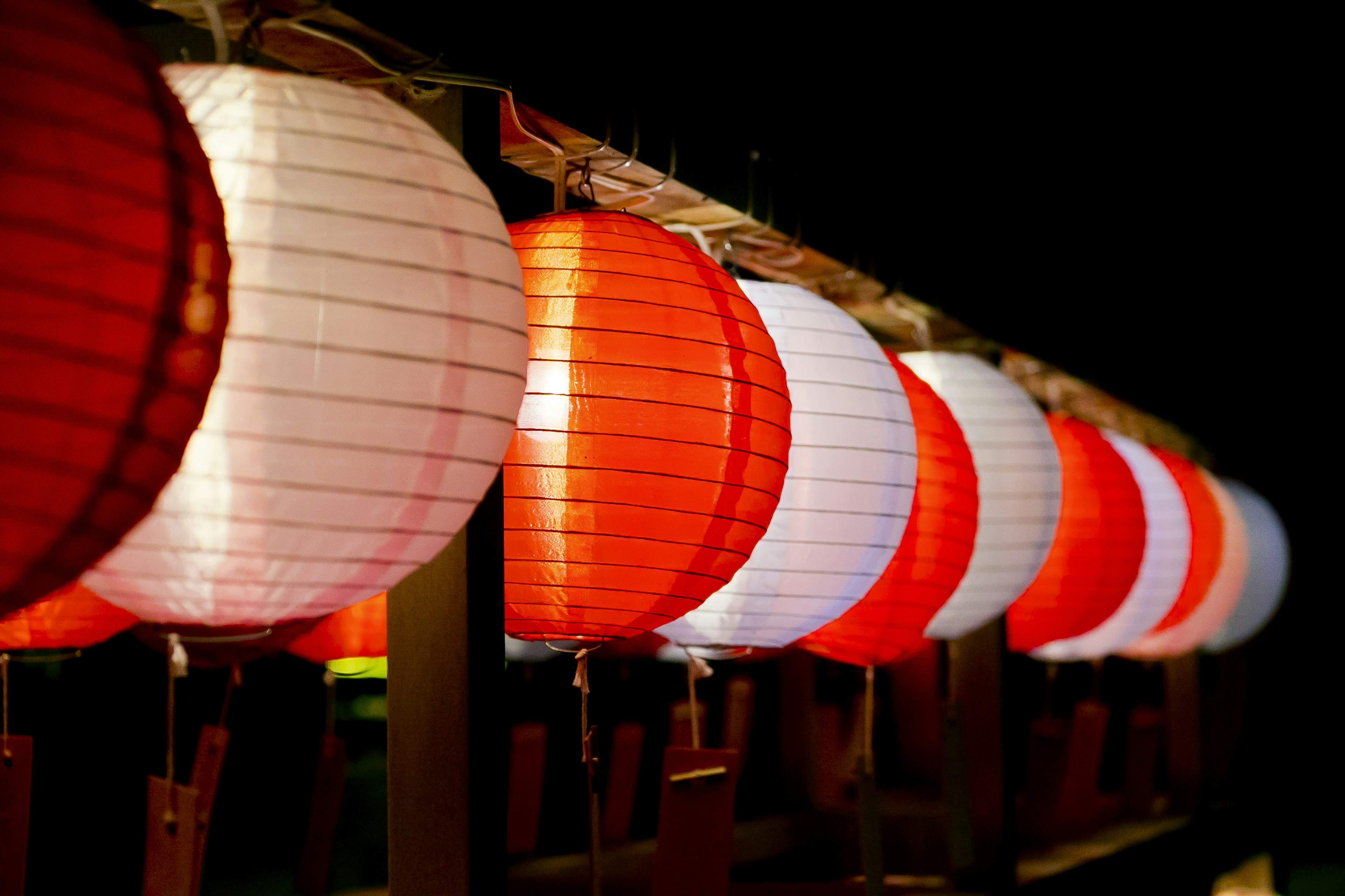 Red and white lanterns lined up in a night setting