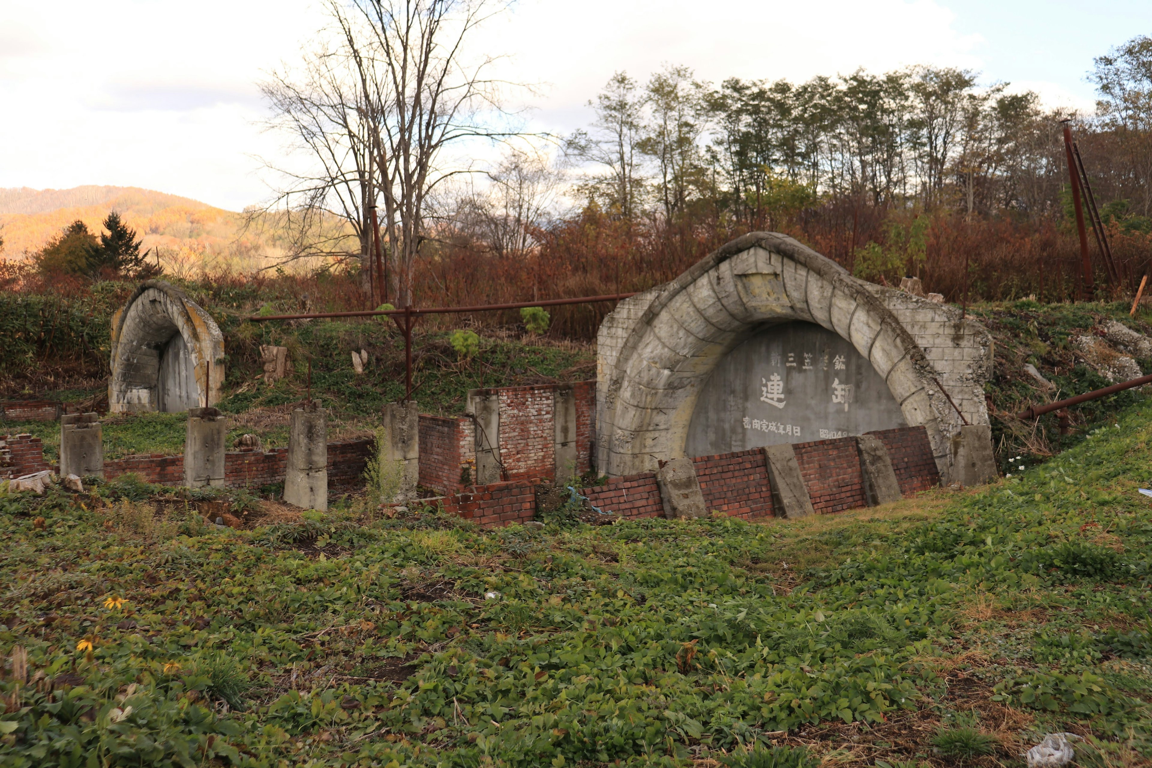 Estructuras de concreto en ruinas parcialmente cubiertas de hierba