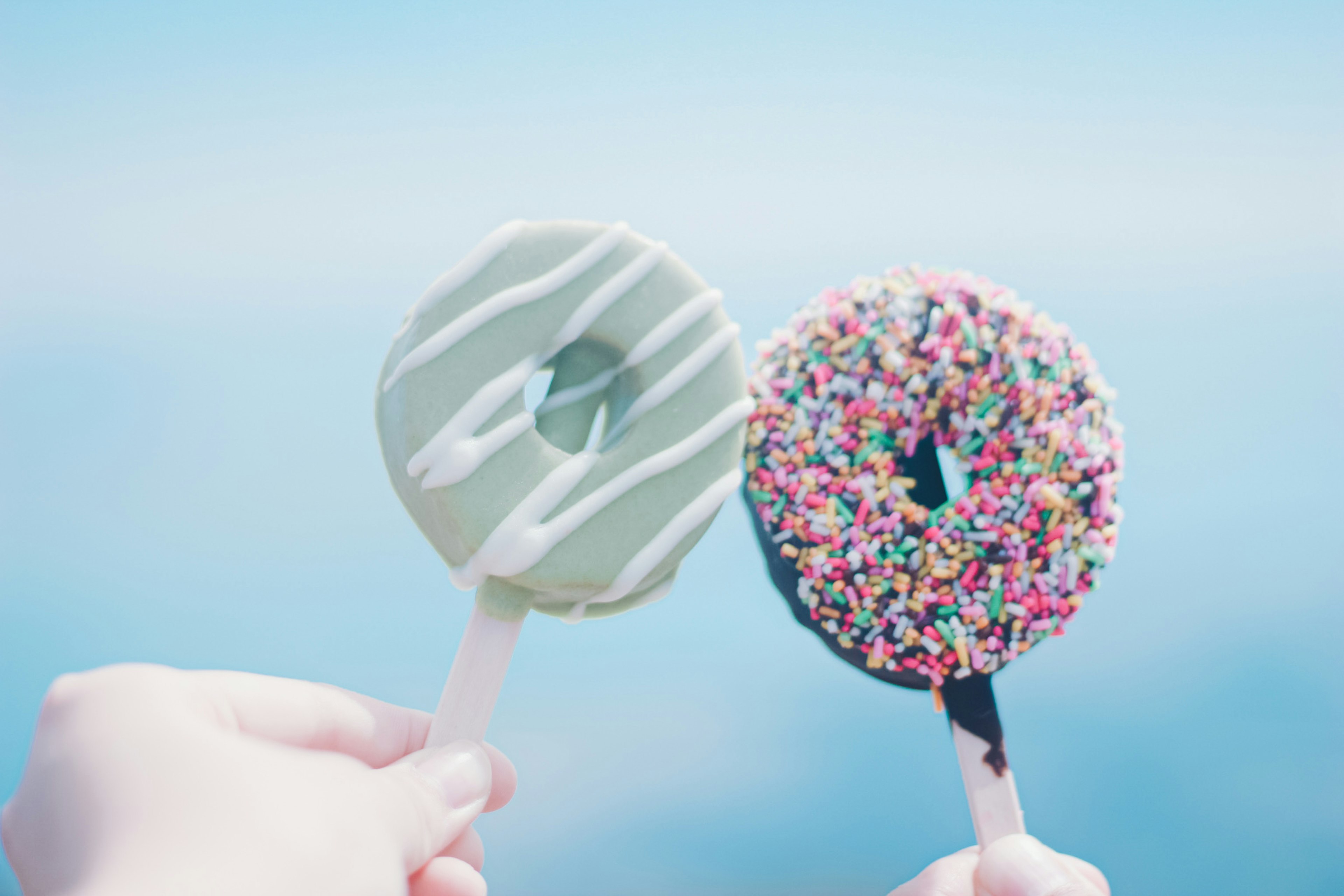 Zwei Eisdoughnuts vor einem blauen Hintergrund