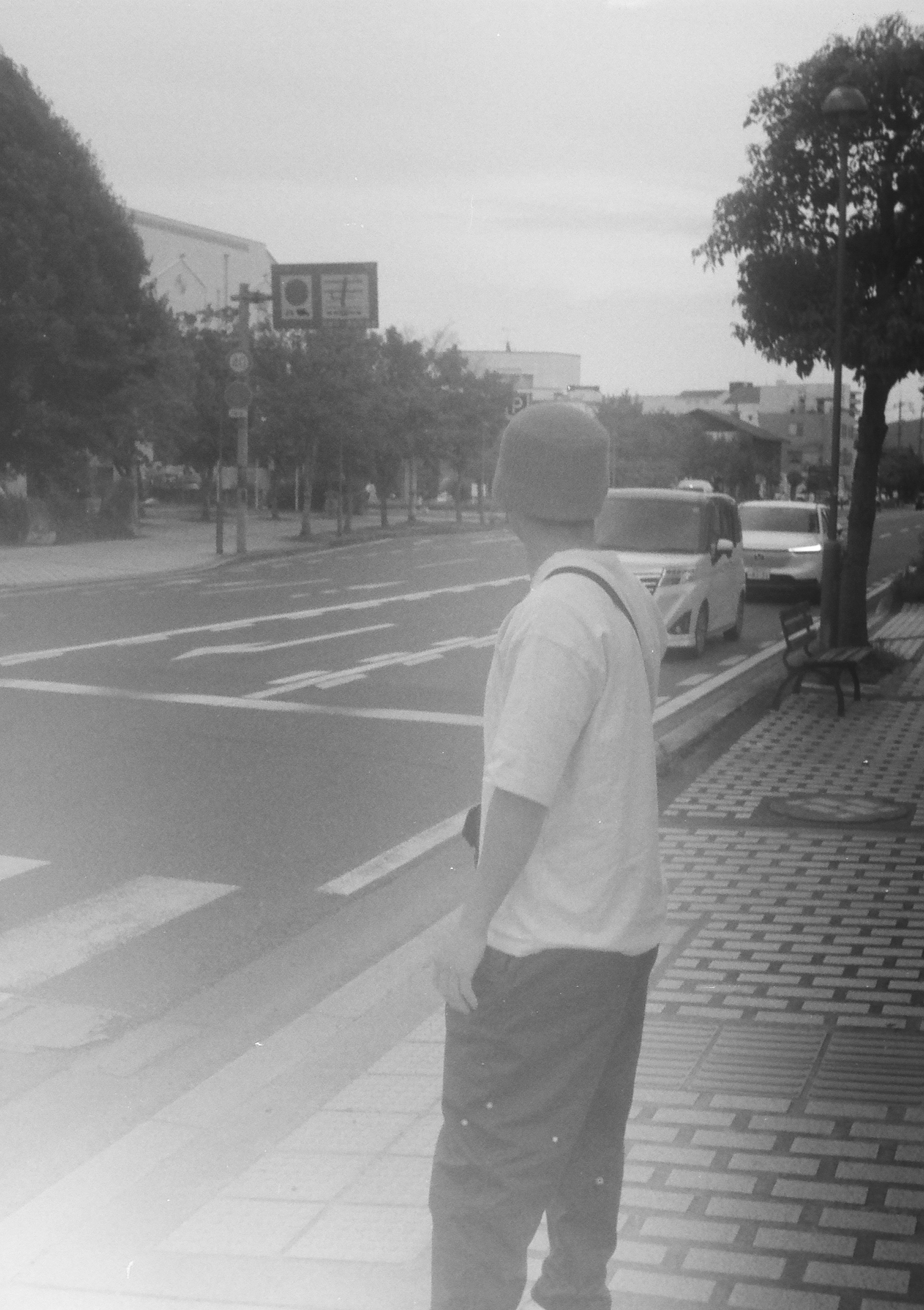 Un uomo di spalle che guarda una strada in bianco e nero