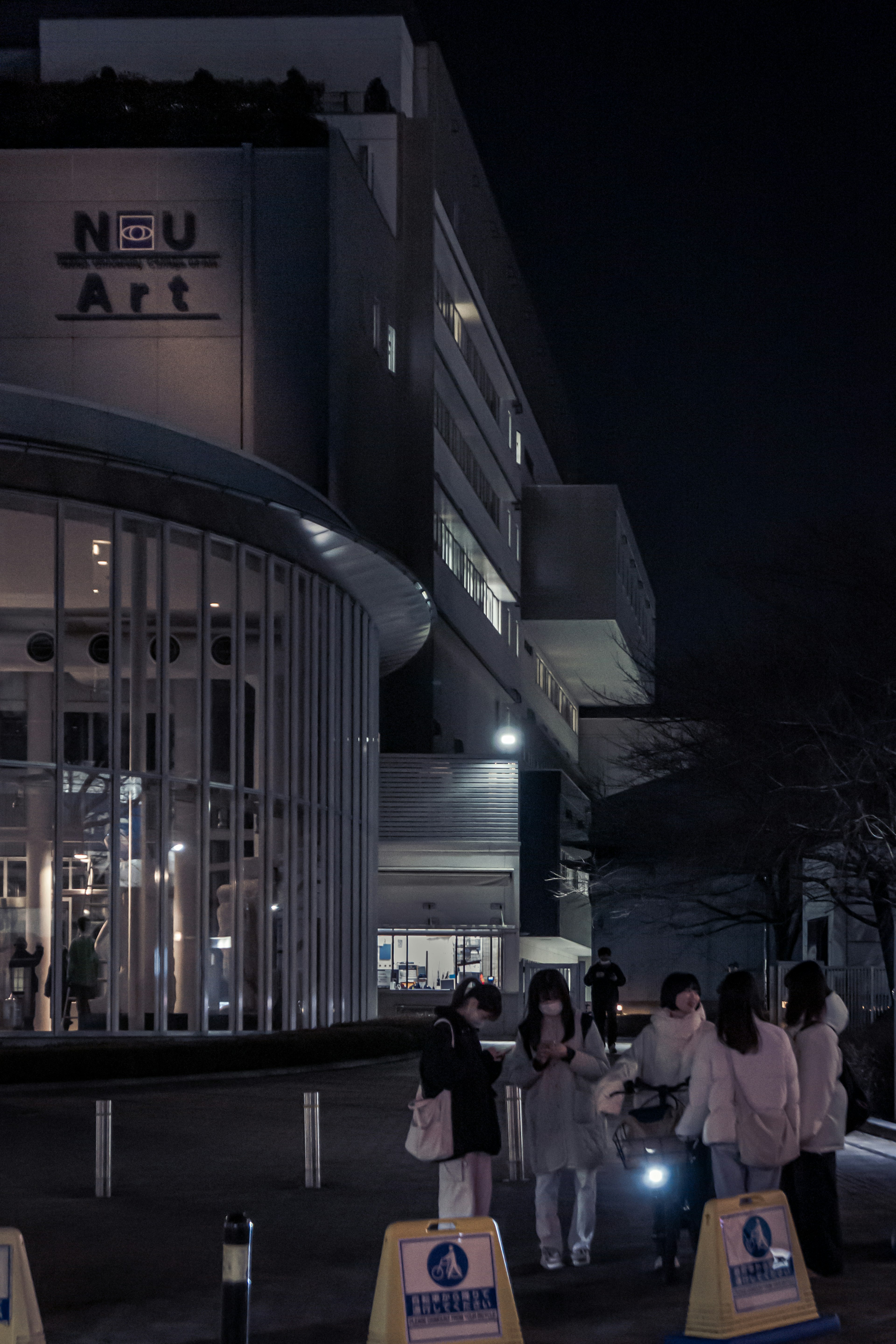 Modern building at night with people gathered outside