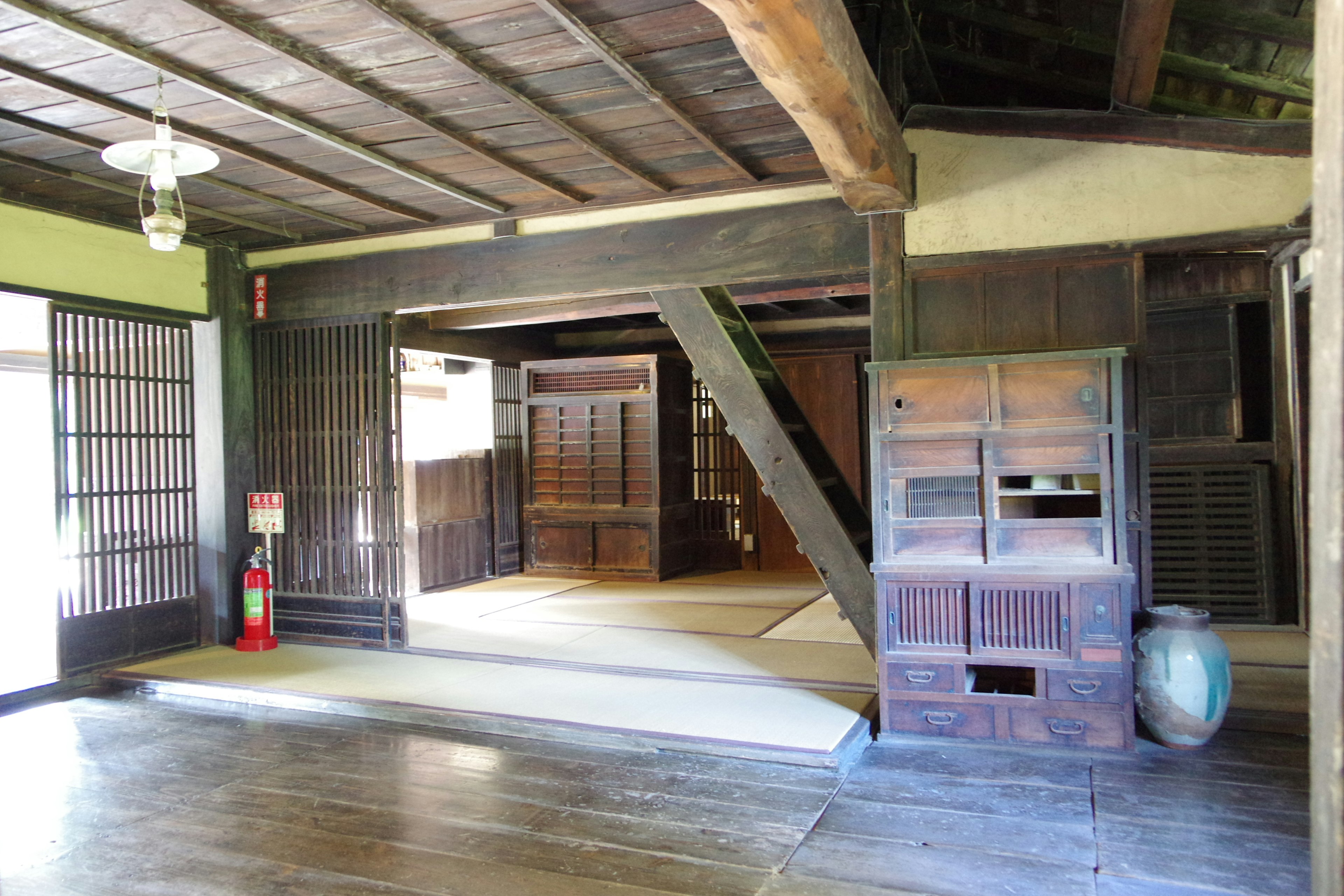 Interior of a traditional Japanese house featuring wooden beams and tatami mats