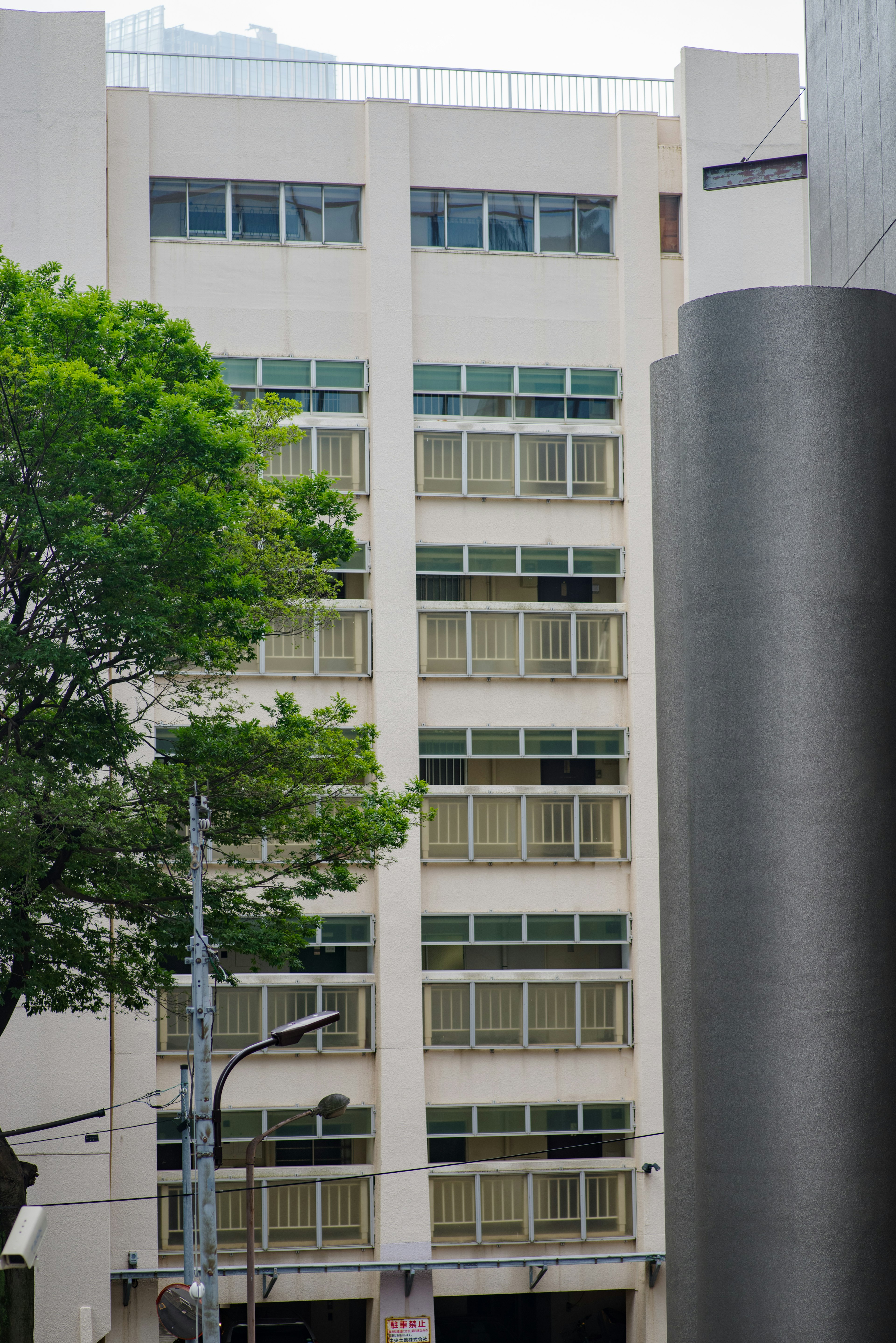 Façade d'un immeuble de grande hauteur avec de la verdure au premier plan