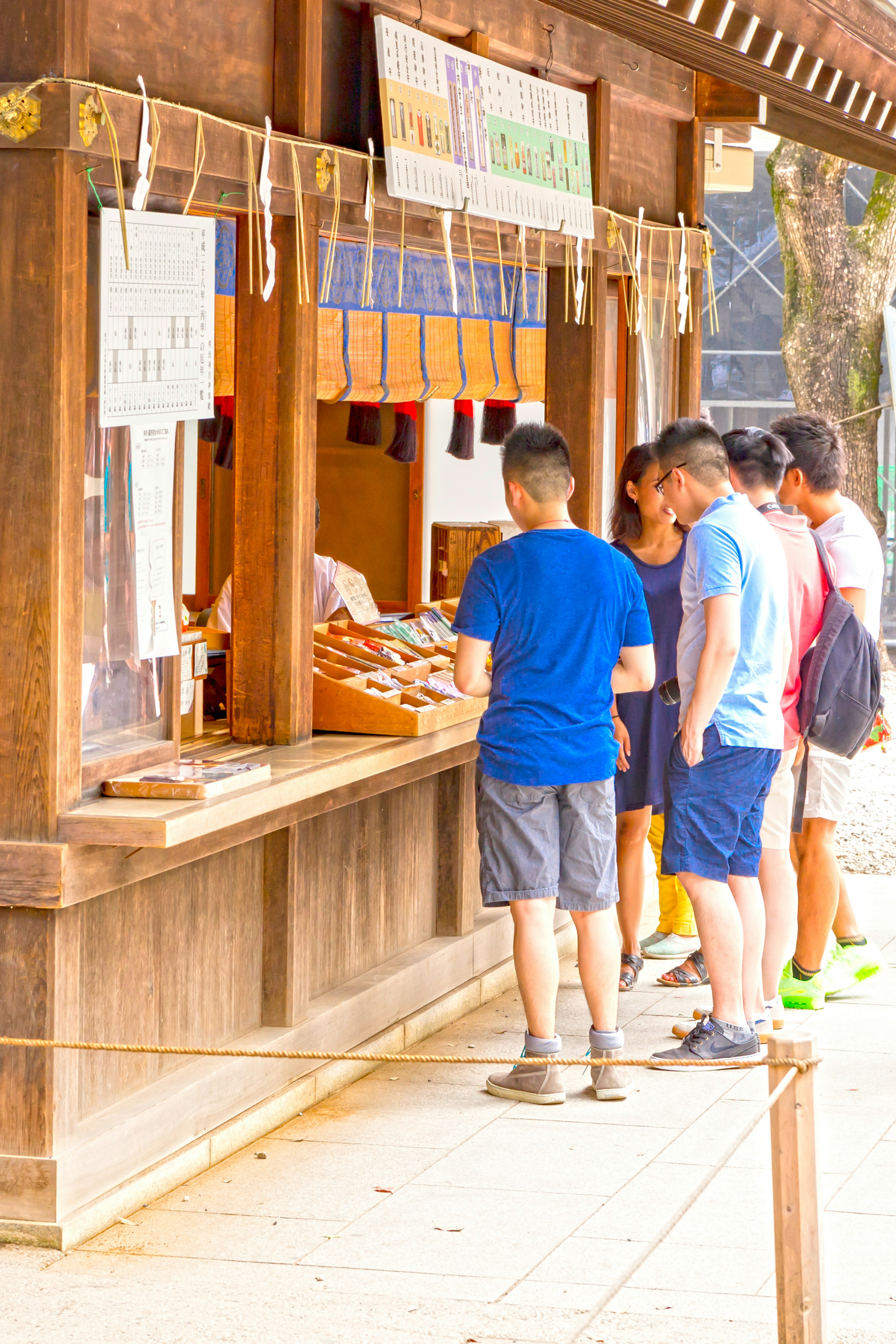 木造の売店の前に並ぶ人々のグループ