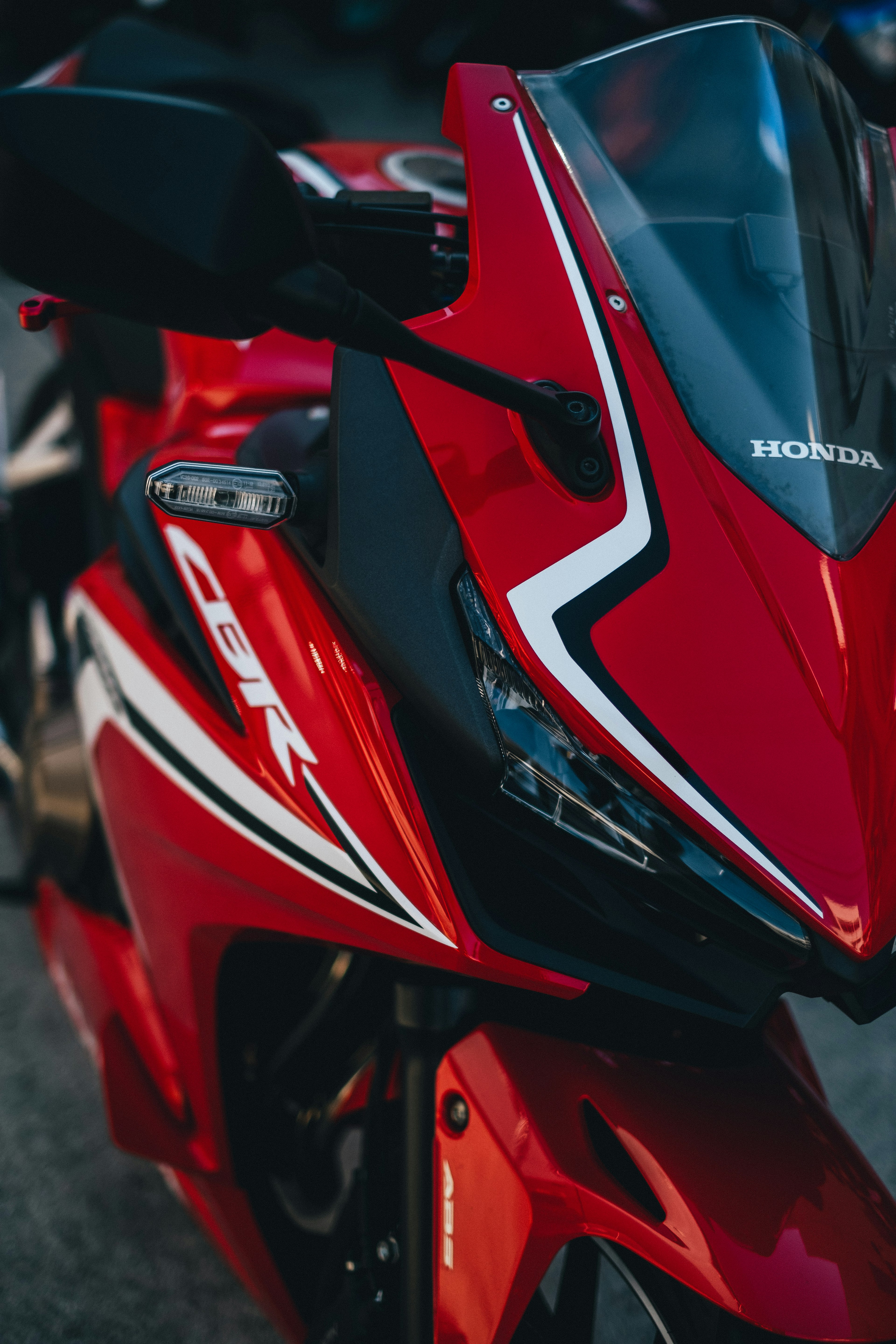 มุมมองด้านหน้าของมอเตอร์ไซค์ Honda CBR สีแดงที่แสดงการออกแบบที่เพรียวบางและเส้นที่คมชัด