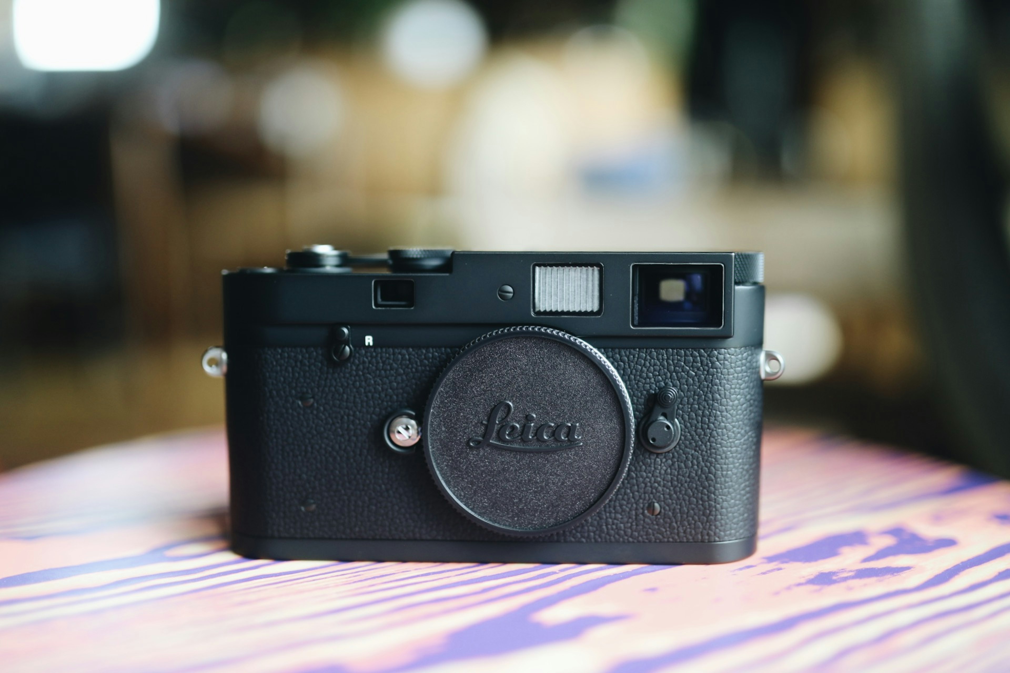 Black Leica camera placed on a wooden table