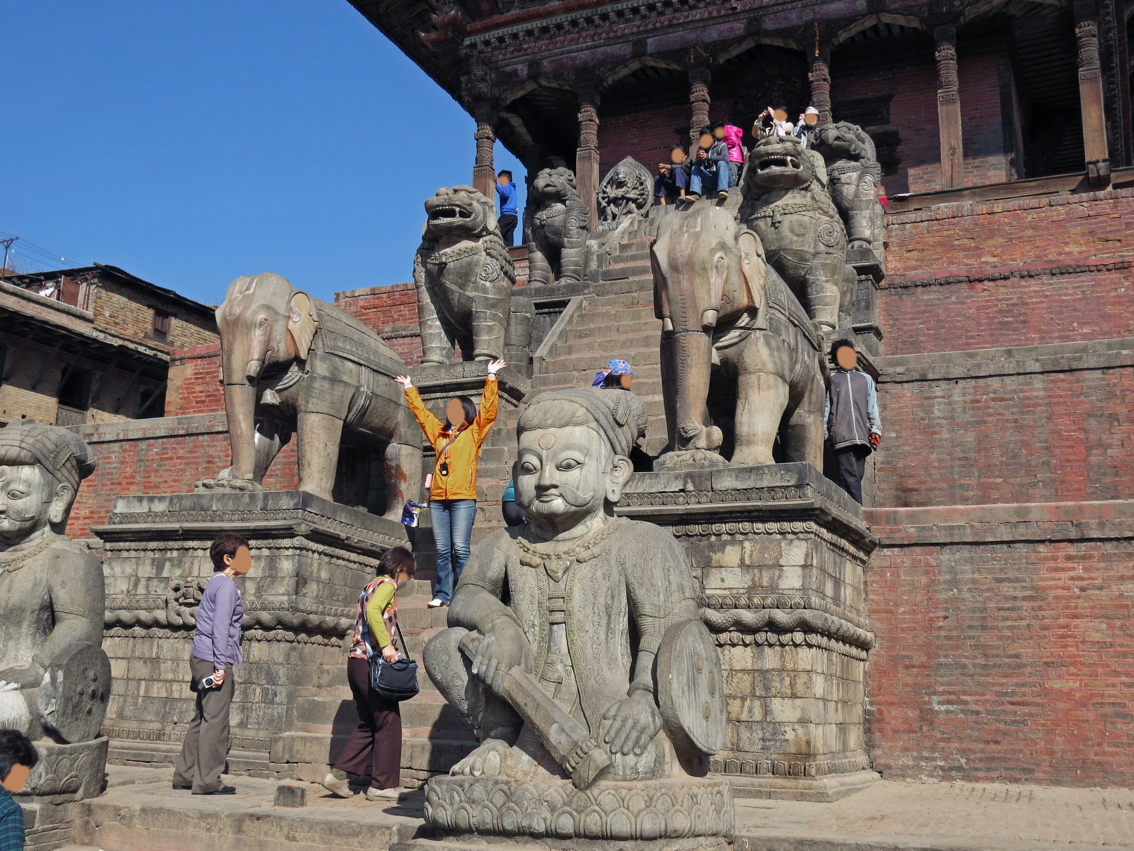 A scene featuring stone statues and people in a square