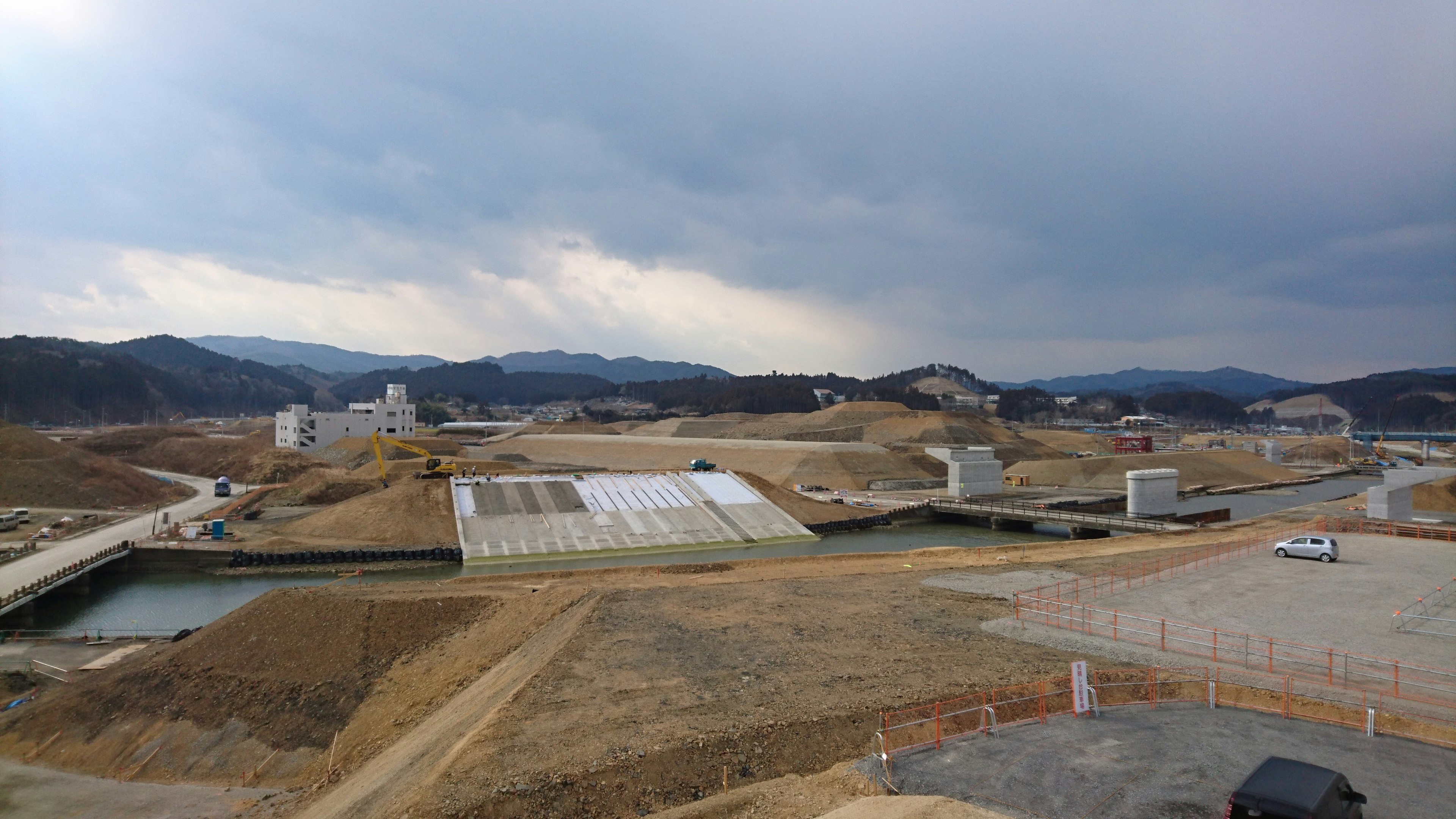 Construction landscape with mountains in the background and overcast sky