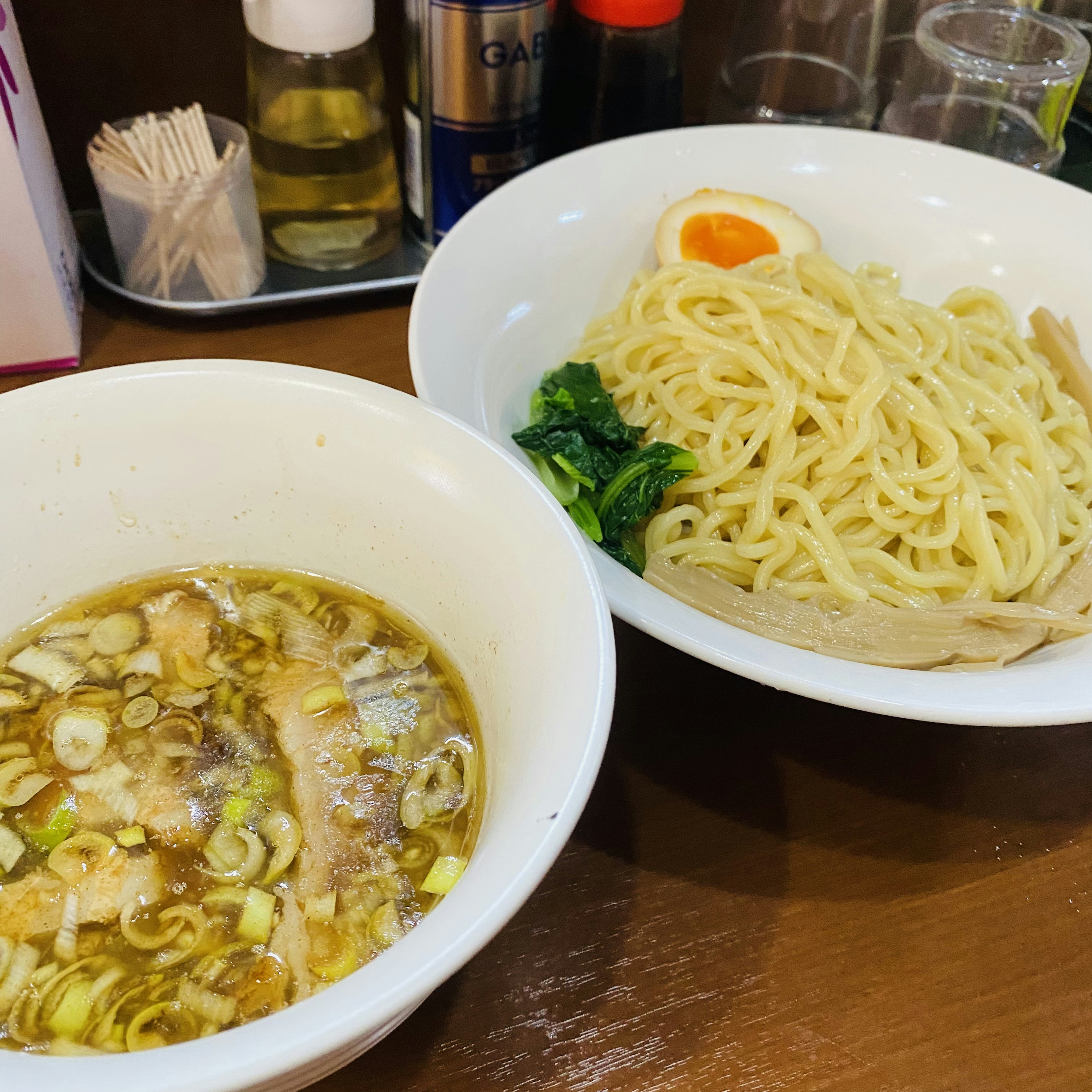 Two bowls of ramen with dipping sauce and noodles