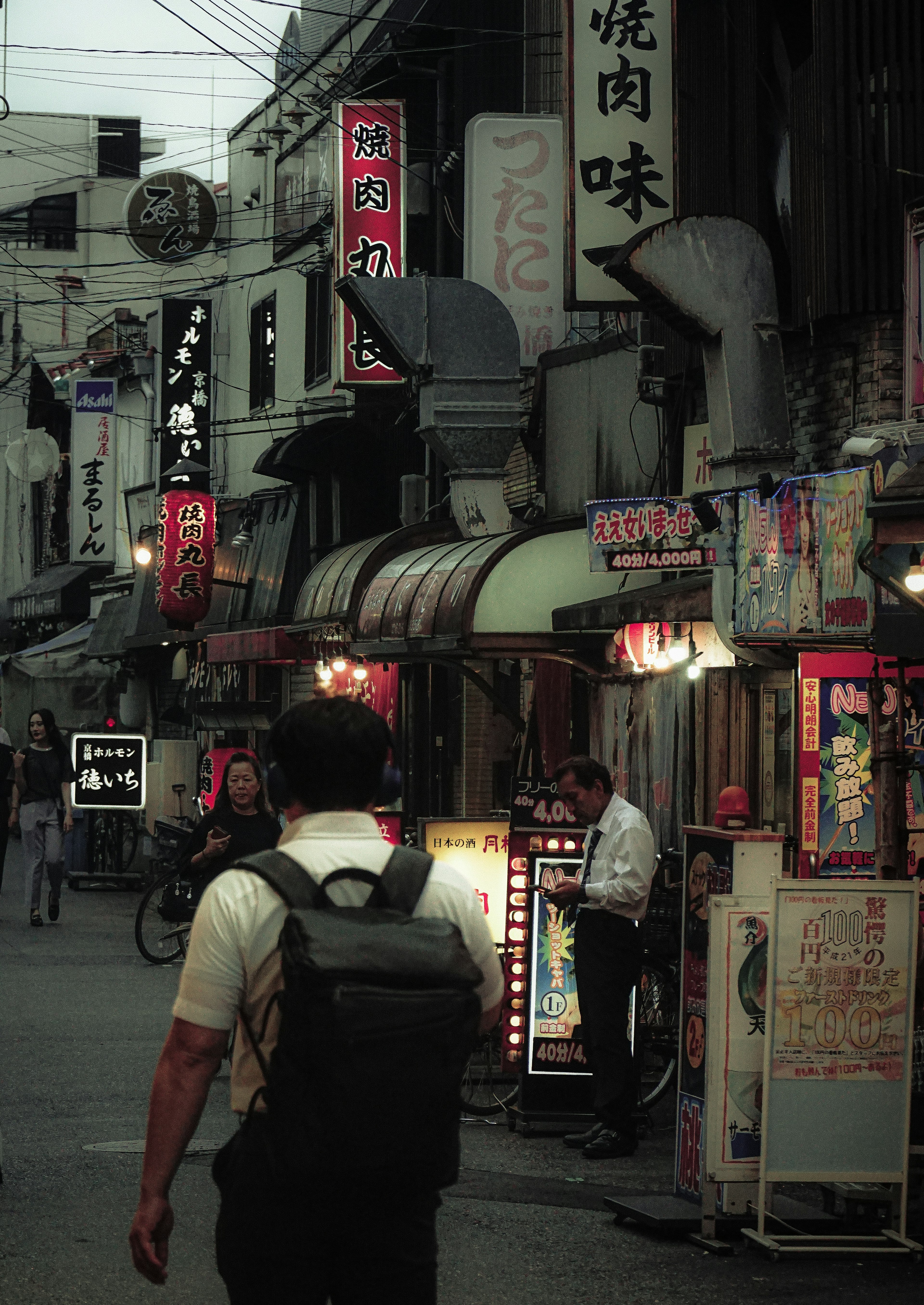 A street lined with restaurants at dusk featuring traditional signage