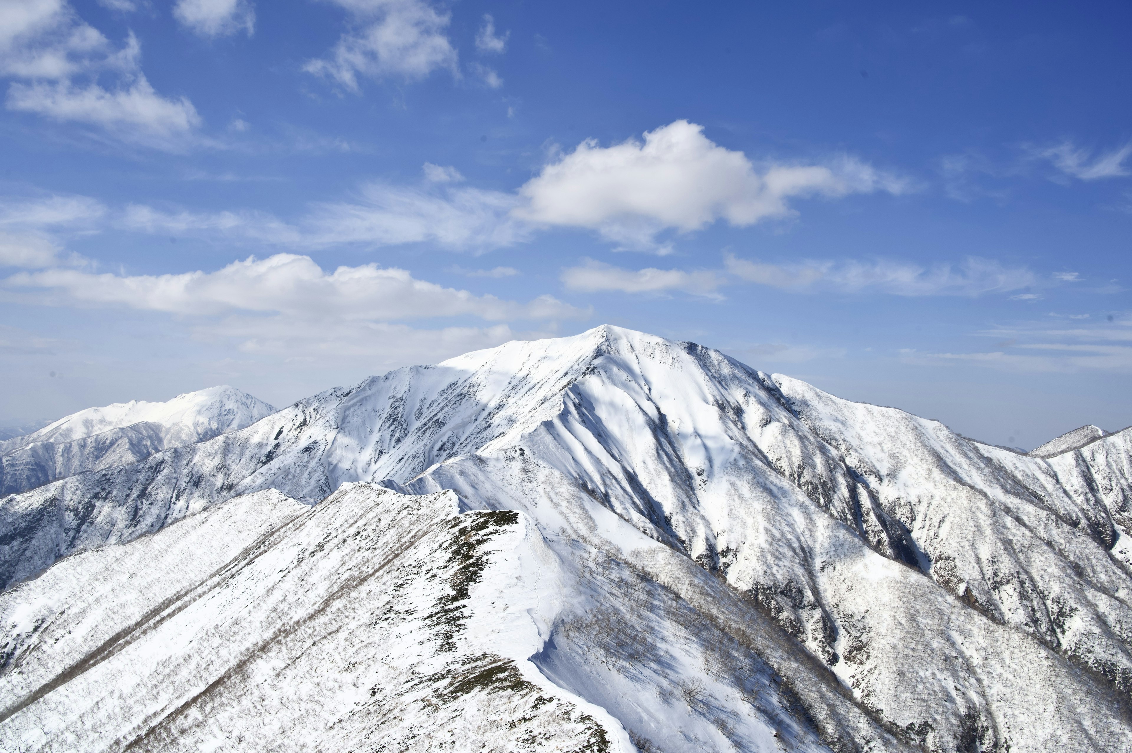 雪に覆われた山々と青い空