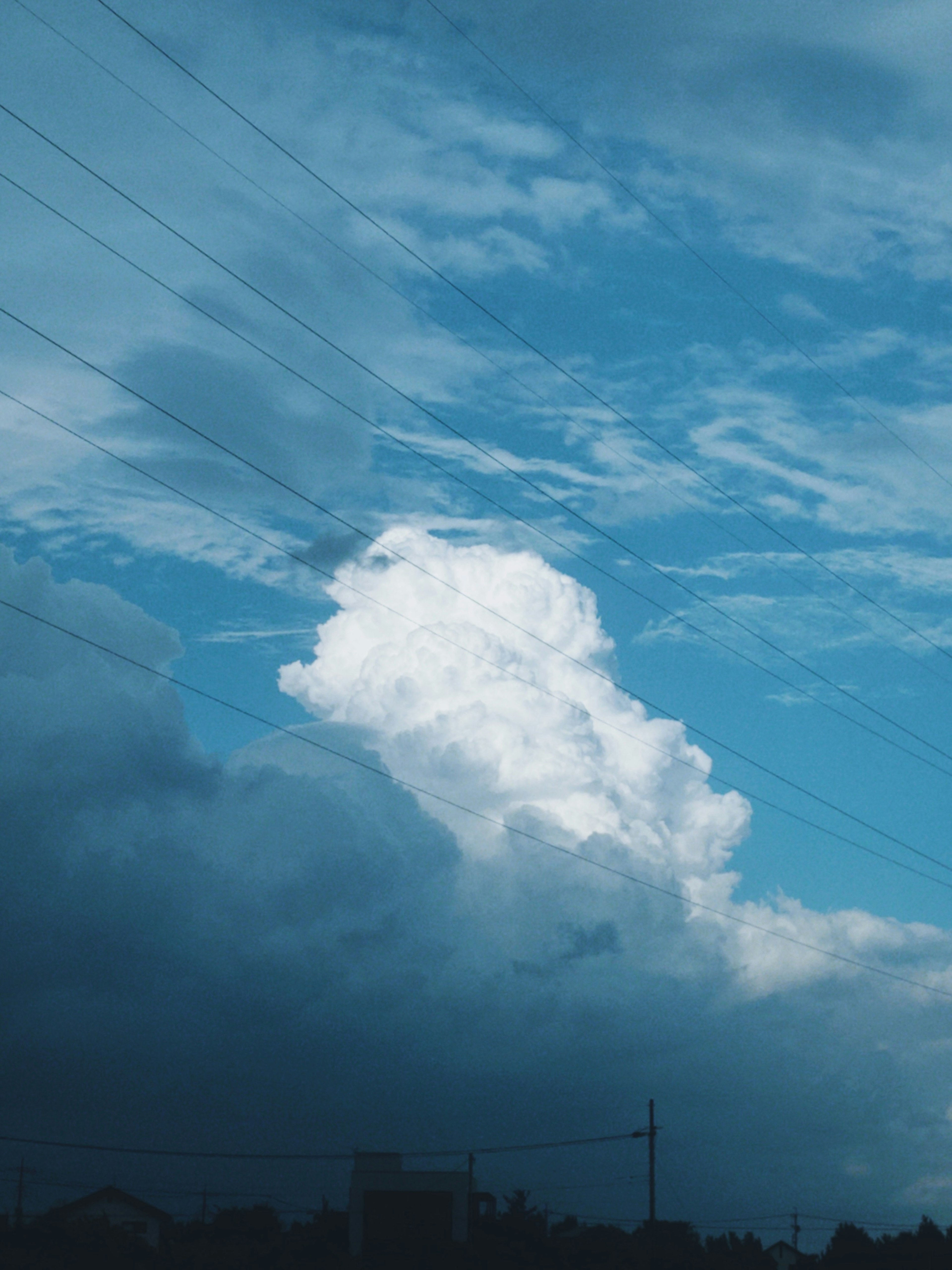 Kontrast von weißen Wolken gegen einen blauen Himmel und dunkle Wolken