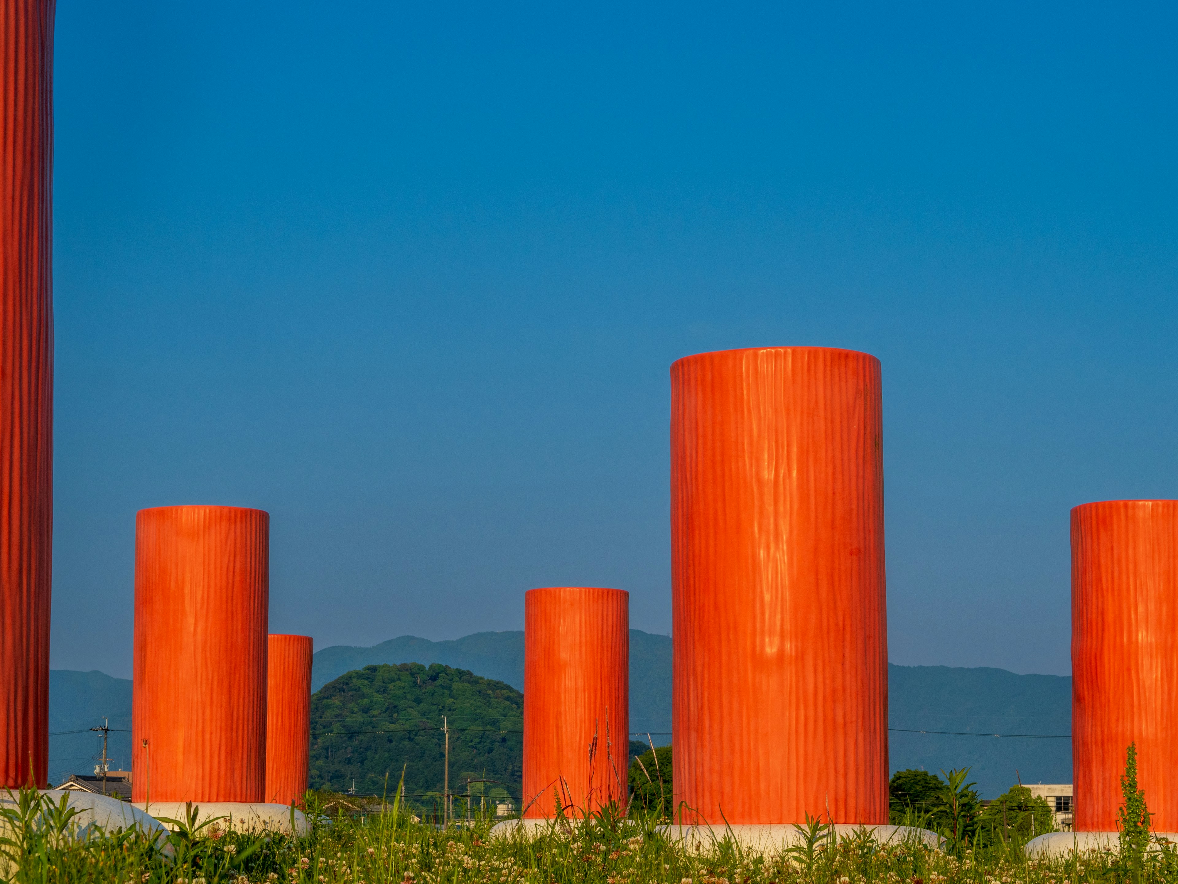 Landscape featuring orange cylindrical pillars under a blue sky