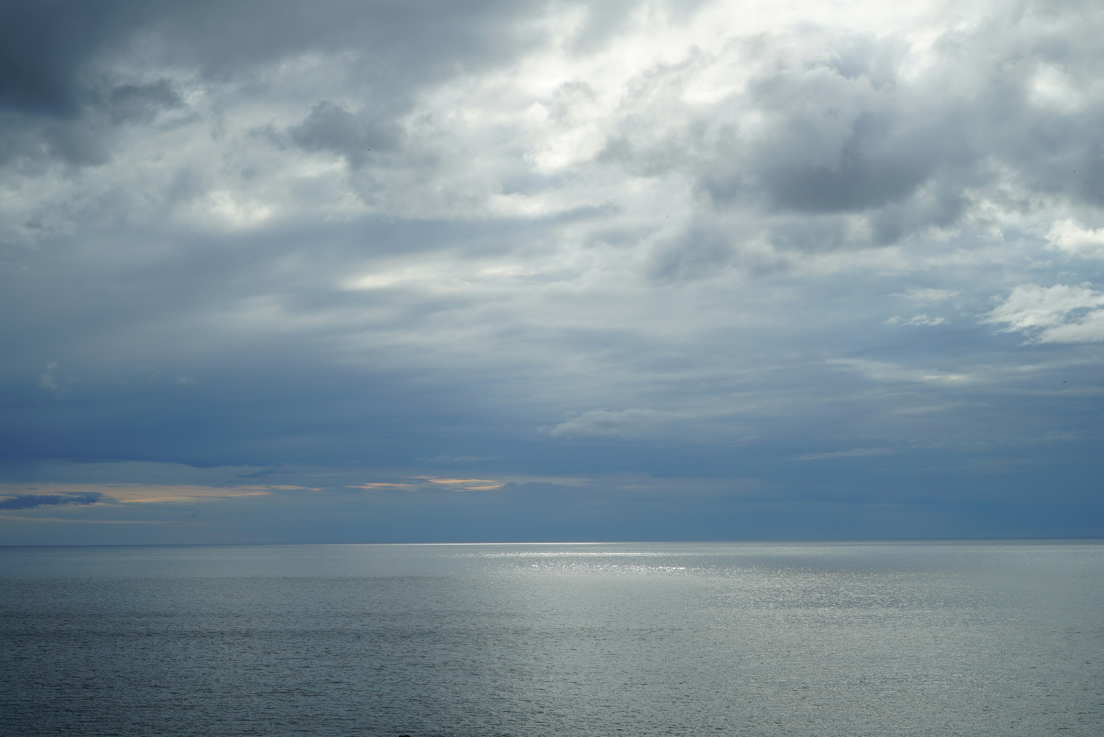 Mer calme sous un ciel nuageux avec de belles réflexions de lumière