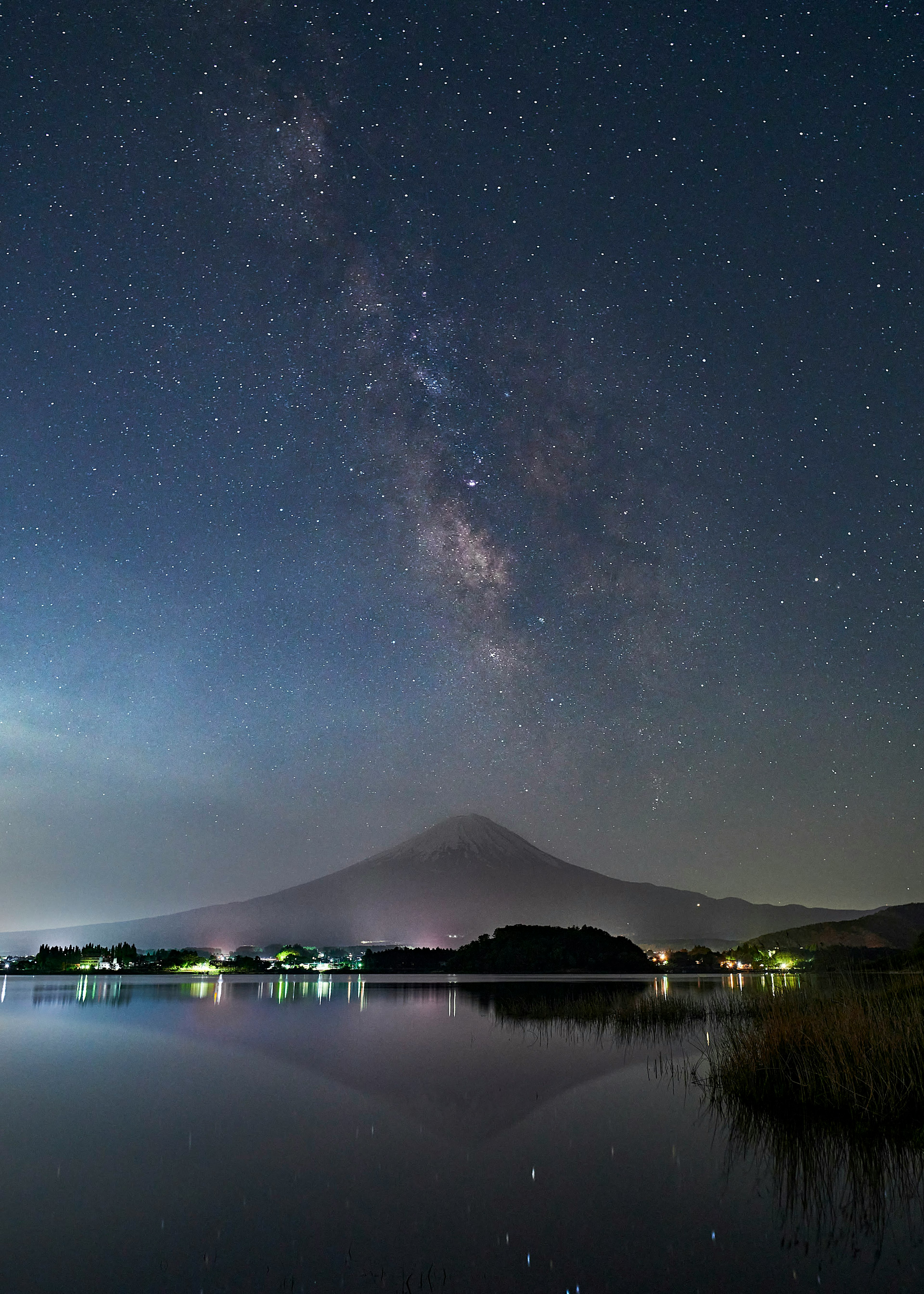 Stunning landscape featuring a mountain and lake under a starry sky