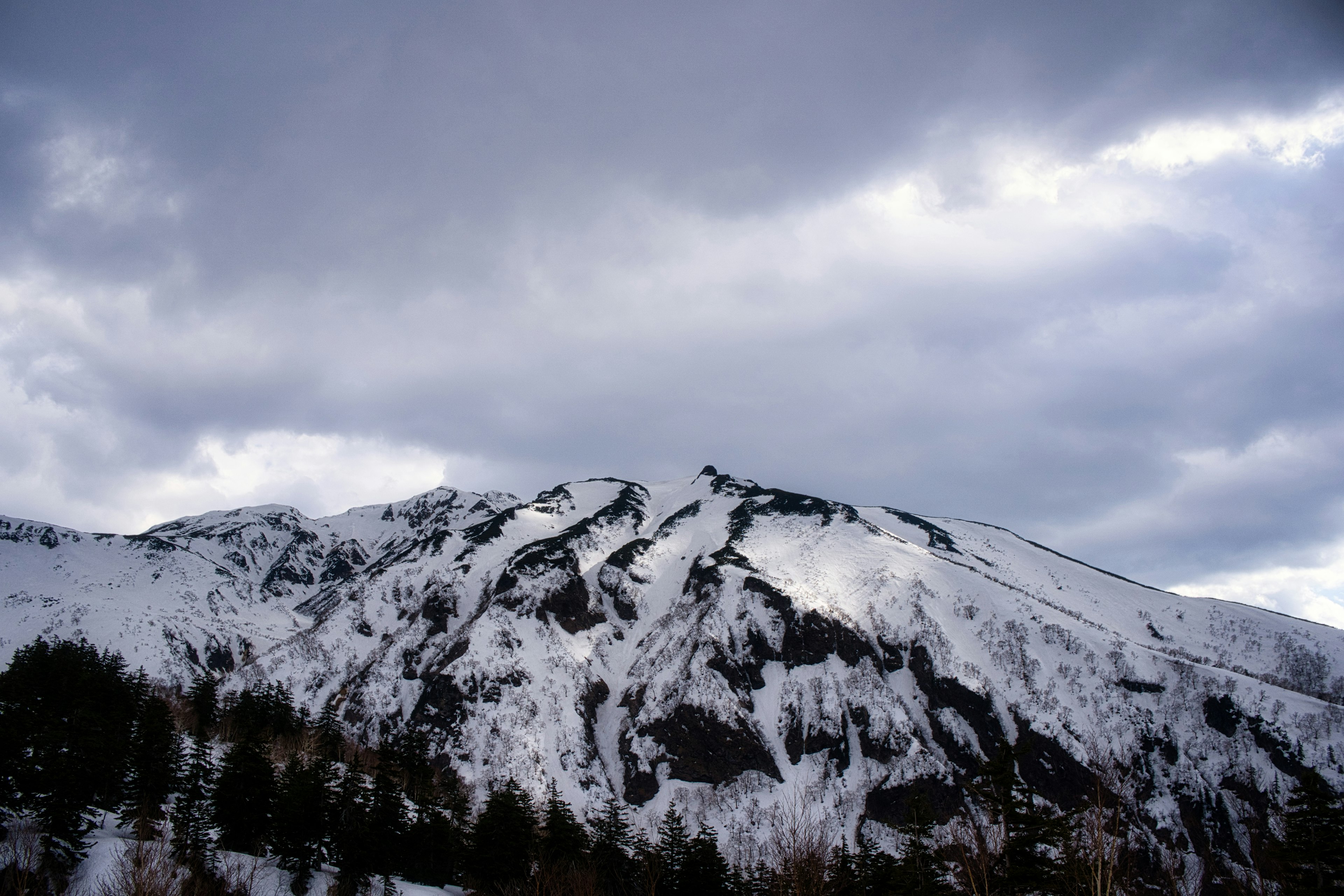 Schneebedeckter Berg unter einem bewölkten Himmel