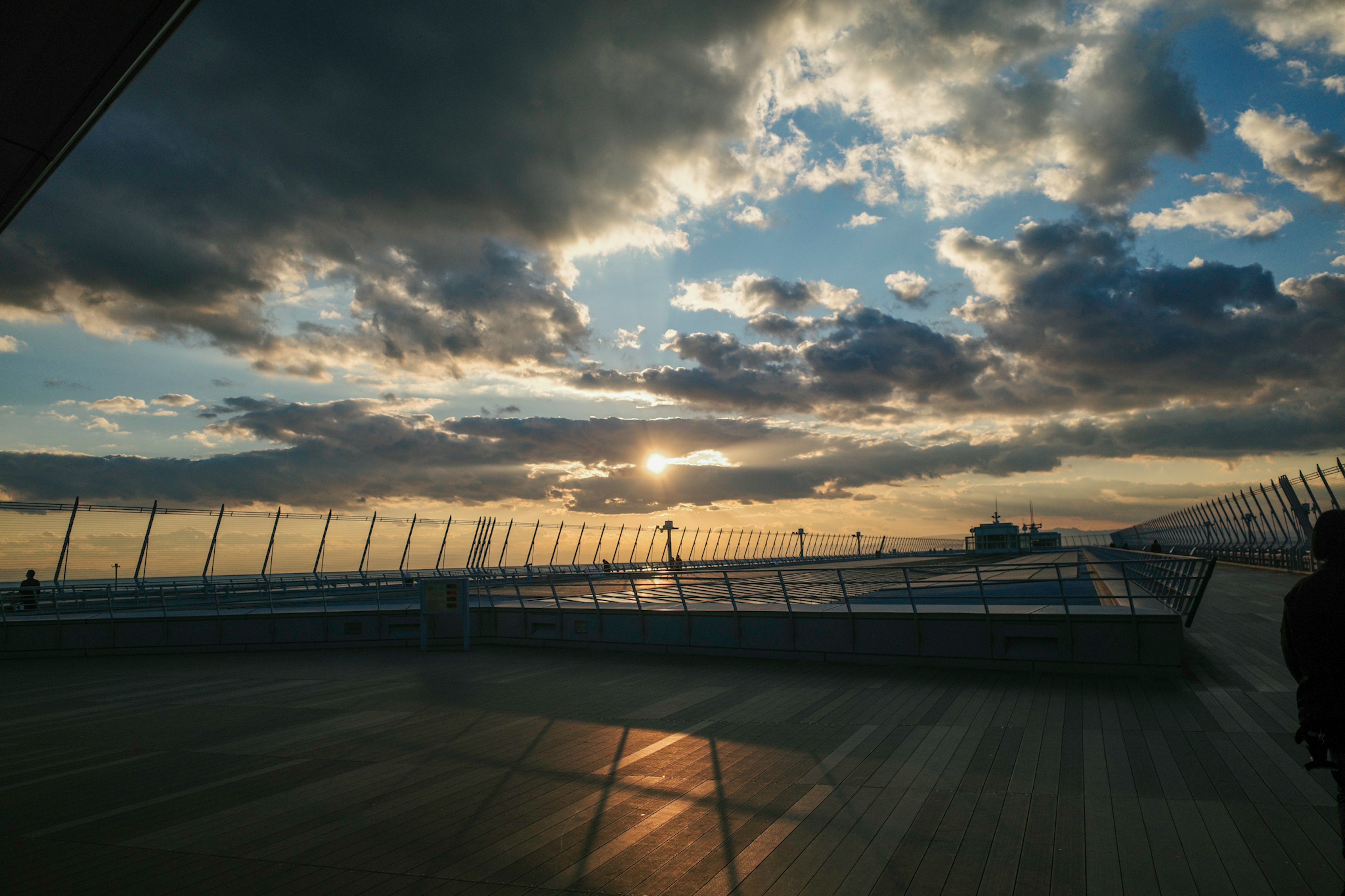 夕日が輝く空と雲の風景を背景にした広いデッキ